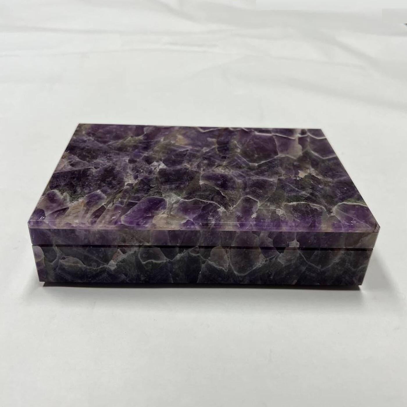Les bijoux préférés trouveront une place luxueuse dans cette boîte précieuse en améthyste fine. Marquée par des lignes épurées, elle capte le regard par les chemins vertigineux tracés par ses veines blanches, entourées de tons violets sensuels