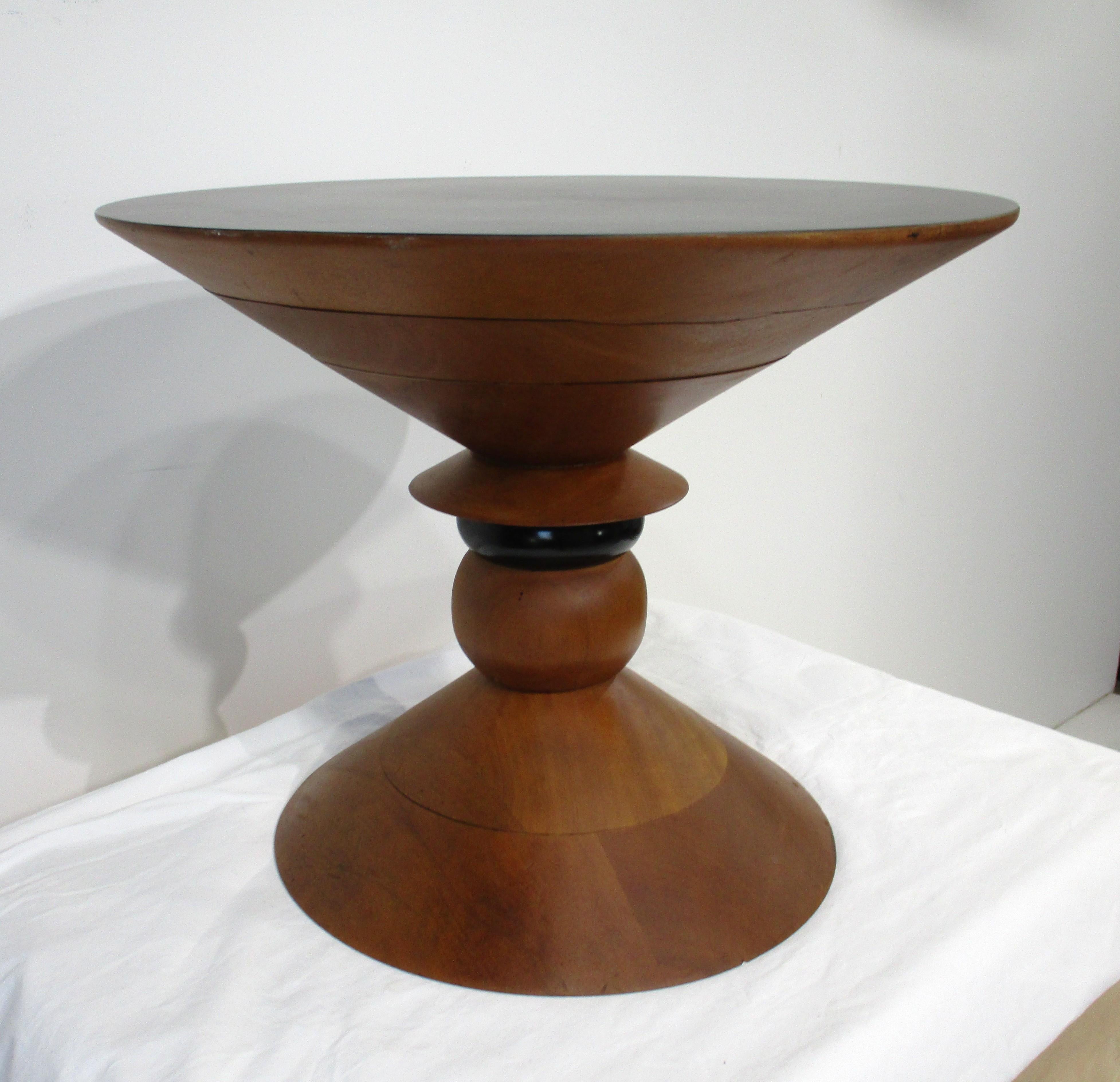 Un prototipo de mesa auxiliar experimental de nogal torneado con el centro pintado de negro y tablero de laminado negro satinado. Esta singular mesa, una de dos, se fabricó a finales de los años 60-70 a la manera de los icónicos taburetes de nogal