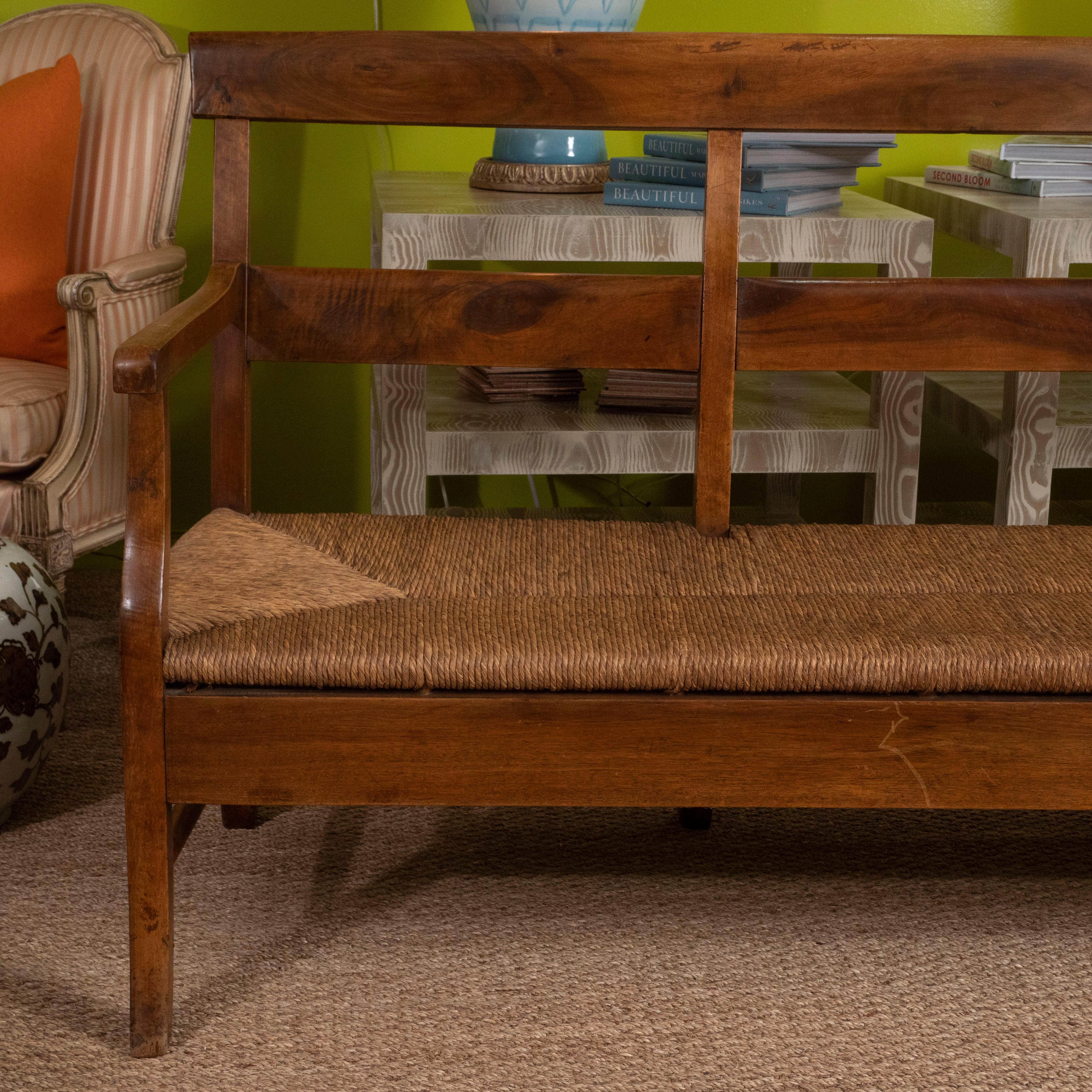 A large Provencal bench made in maple with a woven seat, circa 1840. The maple has developed a beautiful rich patina. We love its clean lines and warm patina, this piece could be dressed up with an upholstered seat or left natural. Perfect for a