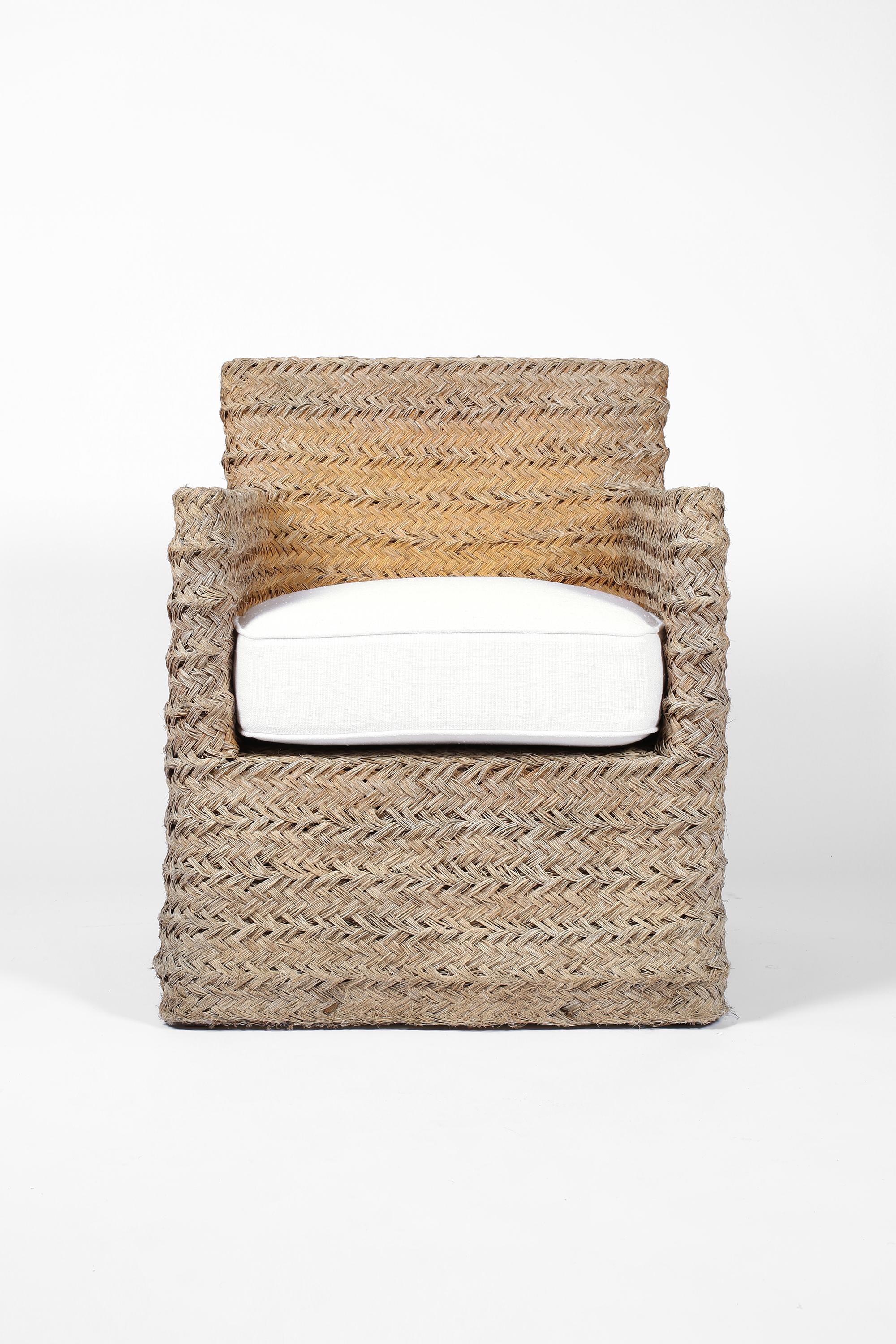 A braided straw armchair from Provence, with newly upholstered seat cushion in textured white linen. In the manner of Adrian Audoux & Frida Minnet. French, c. 1970s.
