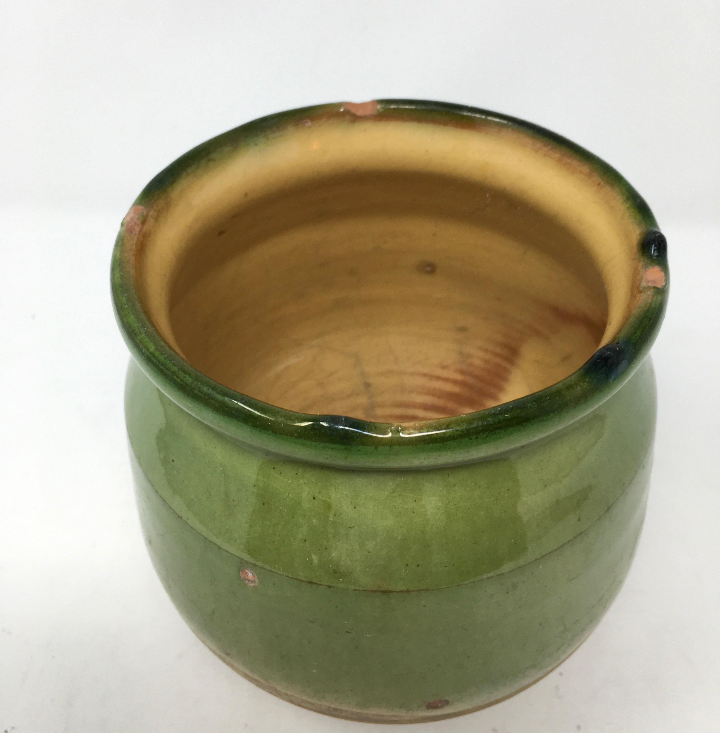 This provencial confit pot from the South of France has a beautiful green glaze on the exterior and a lovely yellow glaze on the interior. The piece is a wonderful in size to hold flowers or cooking utensils.

This piece weighs 1.5 lbs.