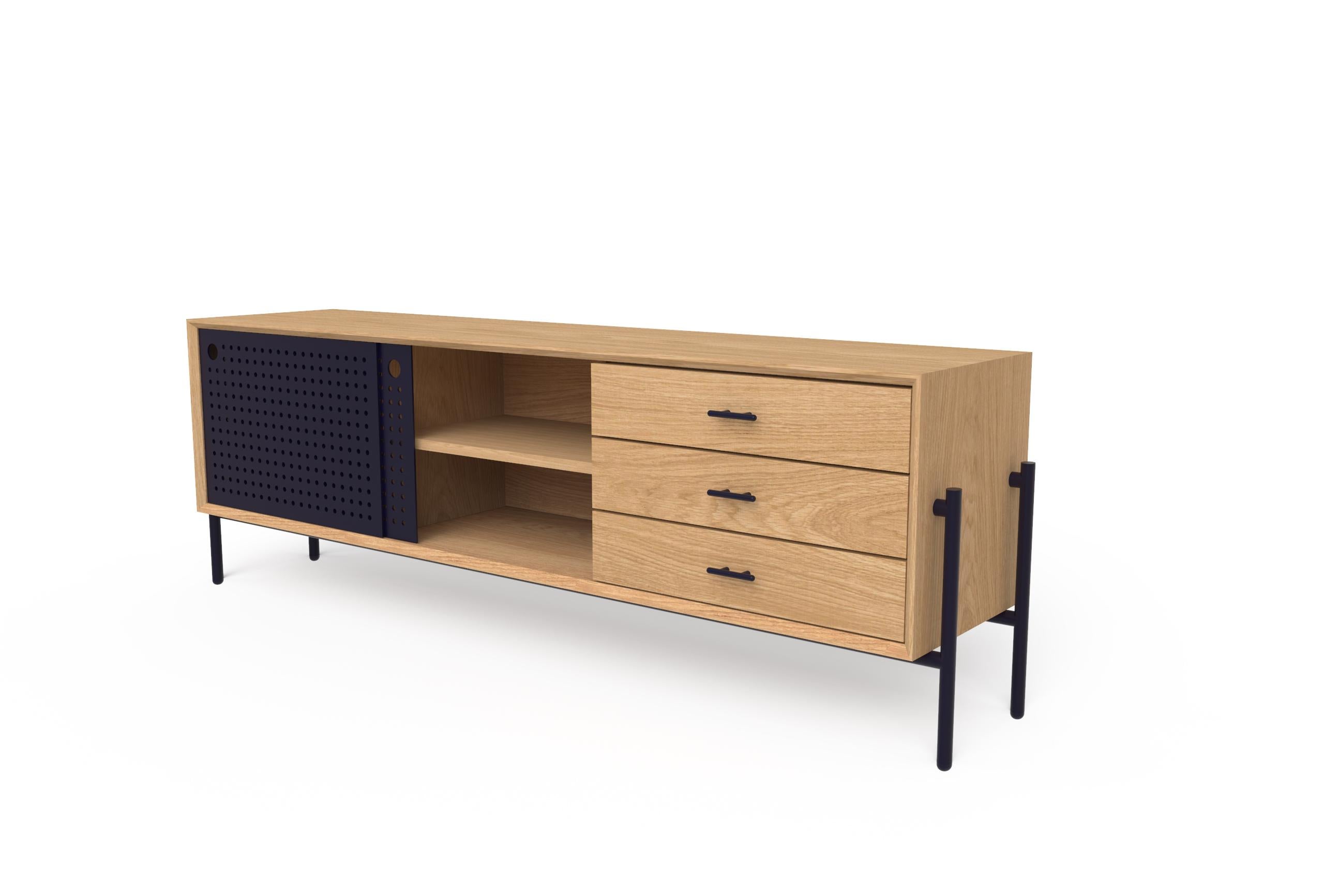 This simple and functional piece was originally conceived for TV rooms.  Its metal sliding doors have a pattern of perforations which allow for remotes to control interior devices. It's made of white oak wood and includes three drawers with metal