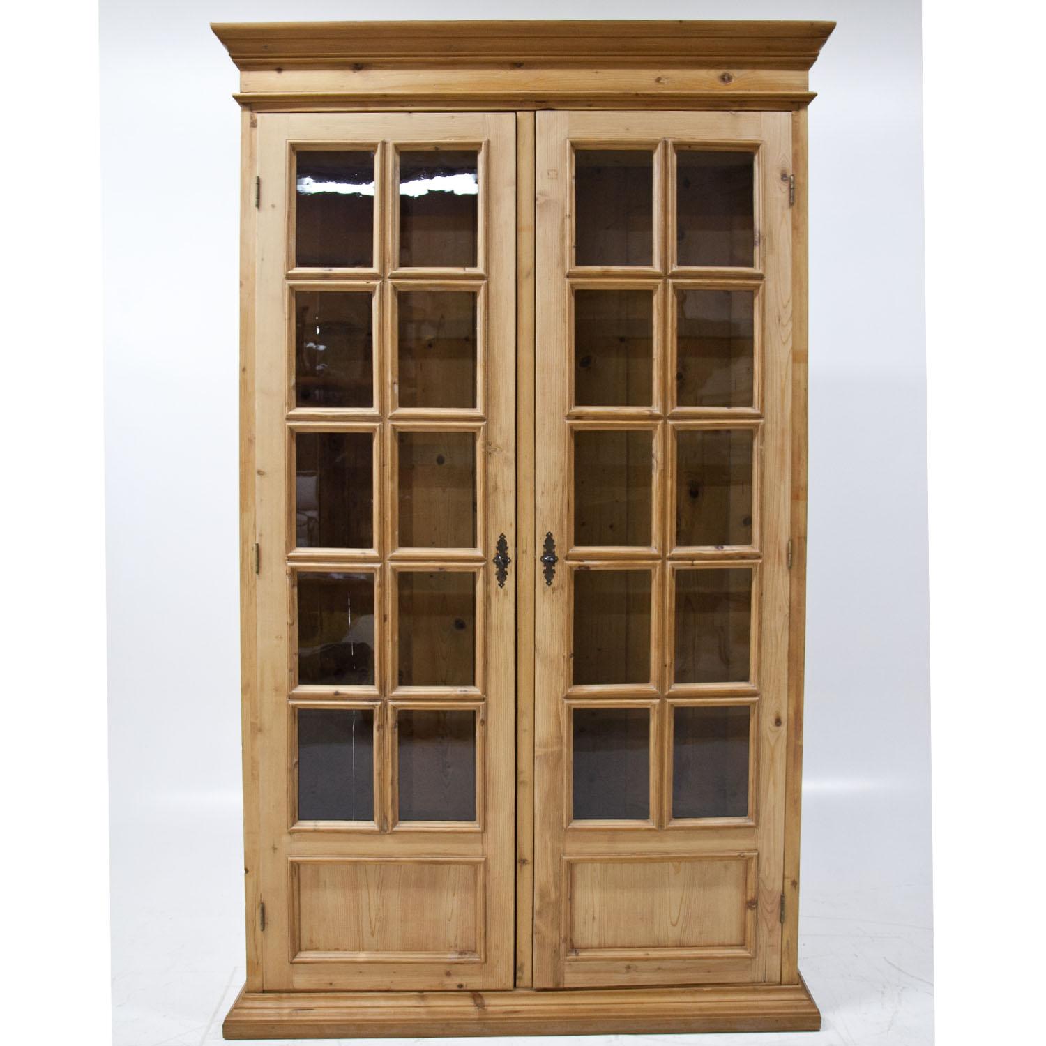 Pair of large Provincial bookcases with slightly protruding bases and cornices as well as glazed doors. The strutting of the doors was redone circa 1970s.