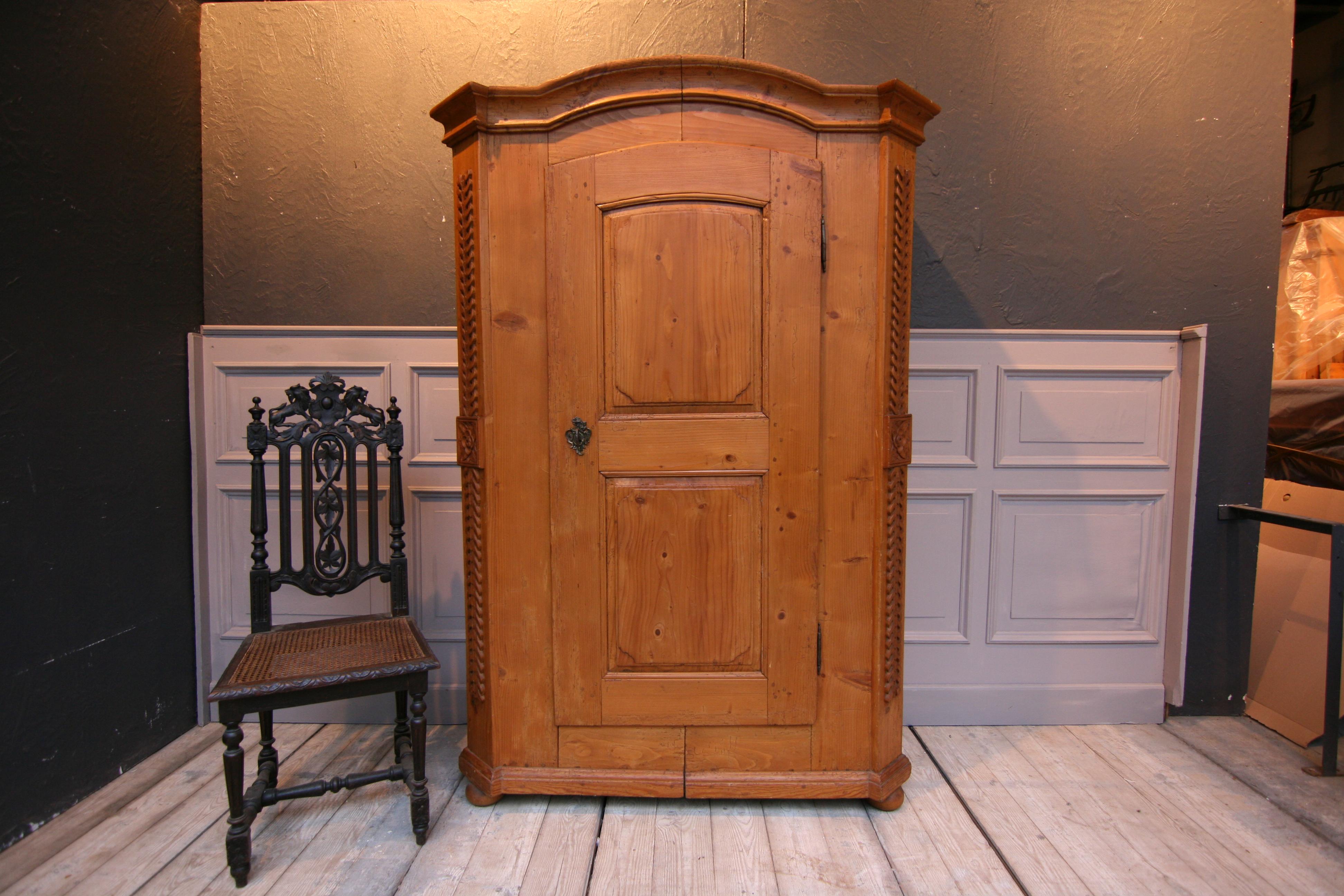Provincial cabinet from the Empire period, circa 1820. Gusset cupboard or split cupboard made of solid pinewood.
Standing on 4 pressed ball feet with bevelled corners with carved floral decoration. Curved cornice. One door made with 2 panels and