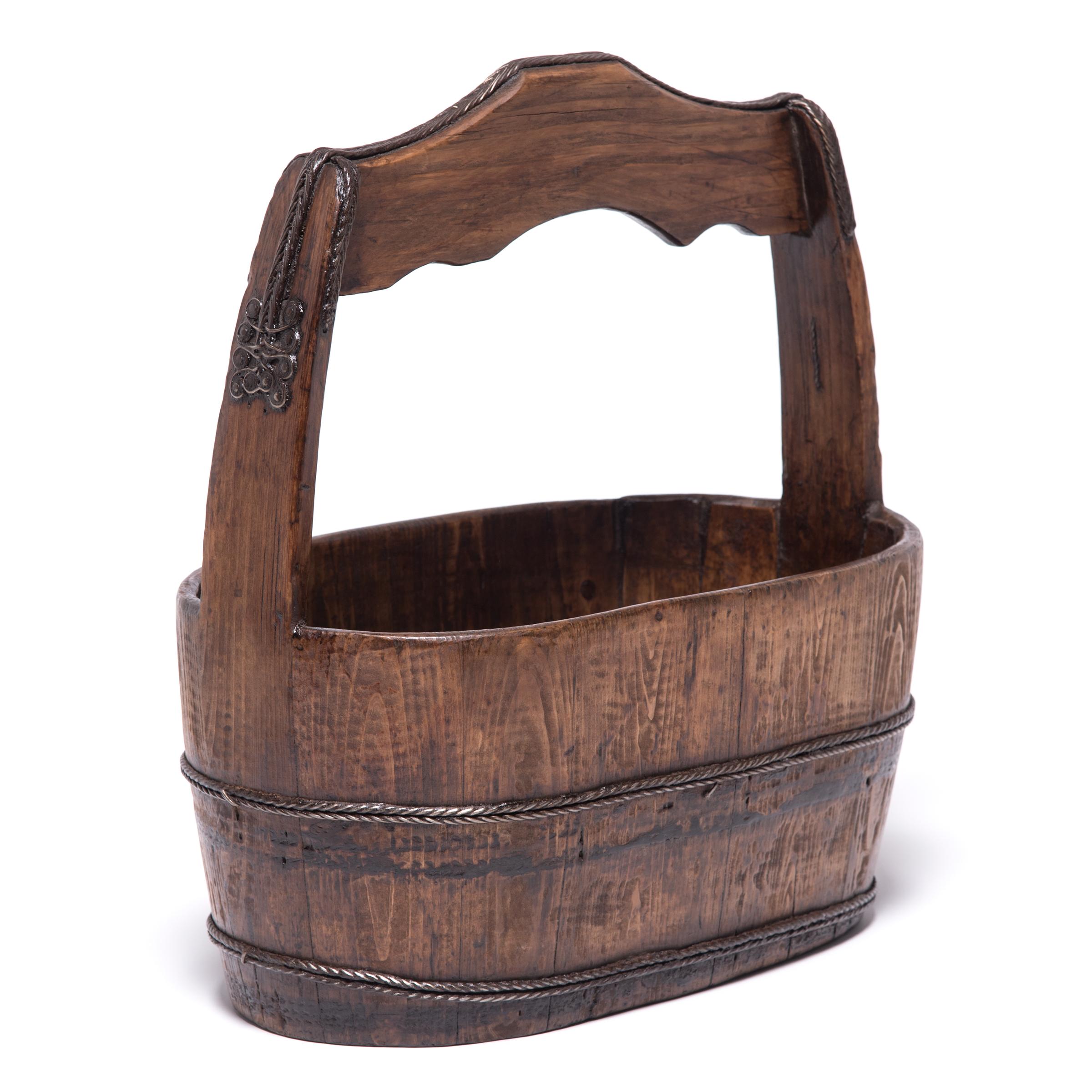 Carved from pine wood, this sturdy bucket made the hard work of harvesting grain a little easier for farmers living in the provincial region of Hebei. Paired with a similar container, the container was balanced on a pole threaded through the large