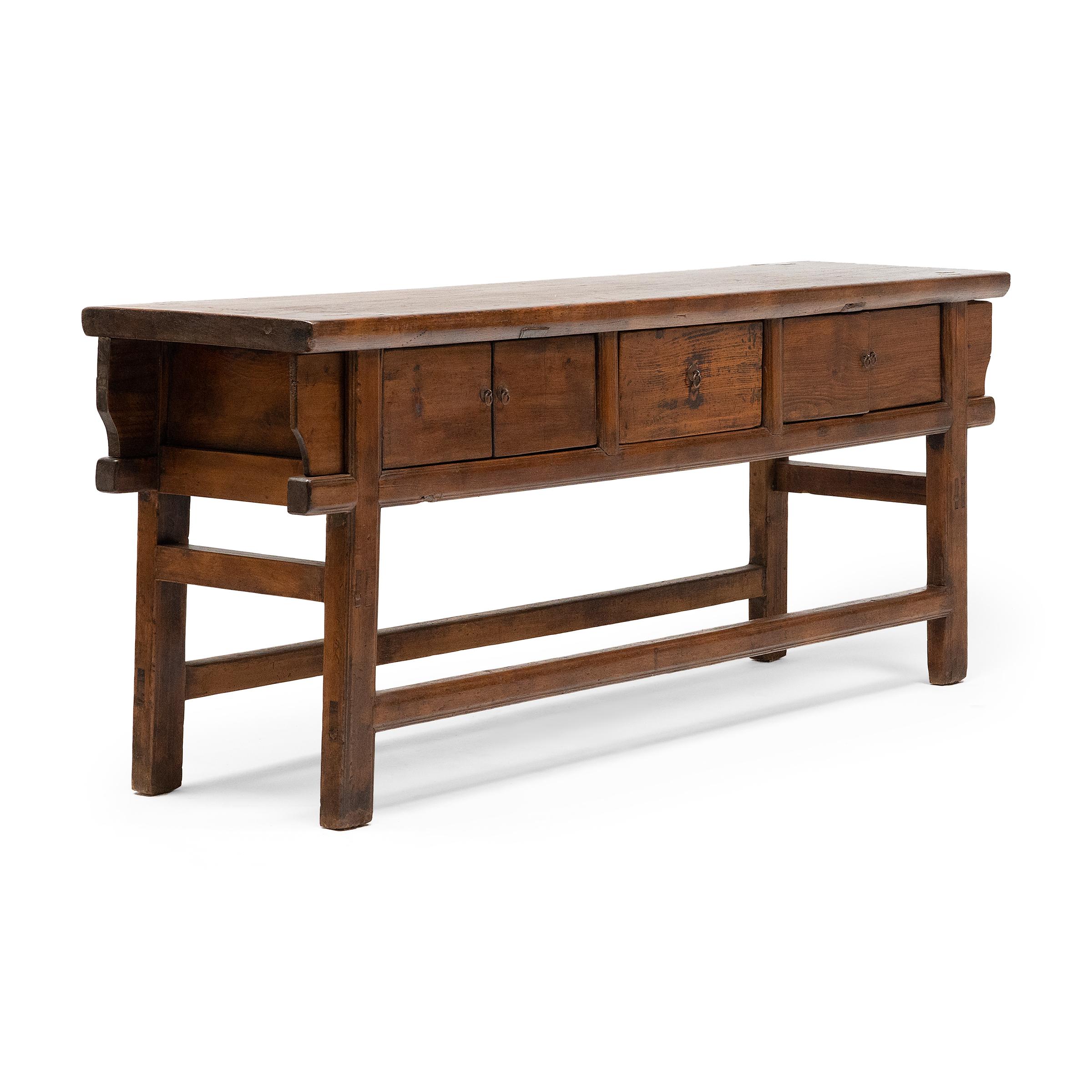 The warm tones and active grain of natural pine wood are the focus of this unusually articulated rustic coffer. Made for a provincial home in northeastern China, this sideboard was once used as a home altar to honor loved ones past and present with