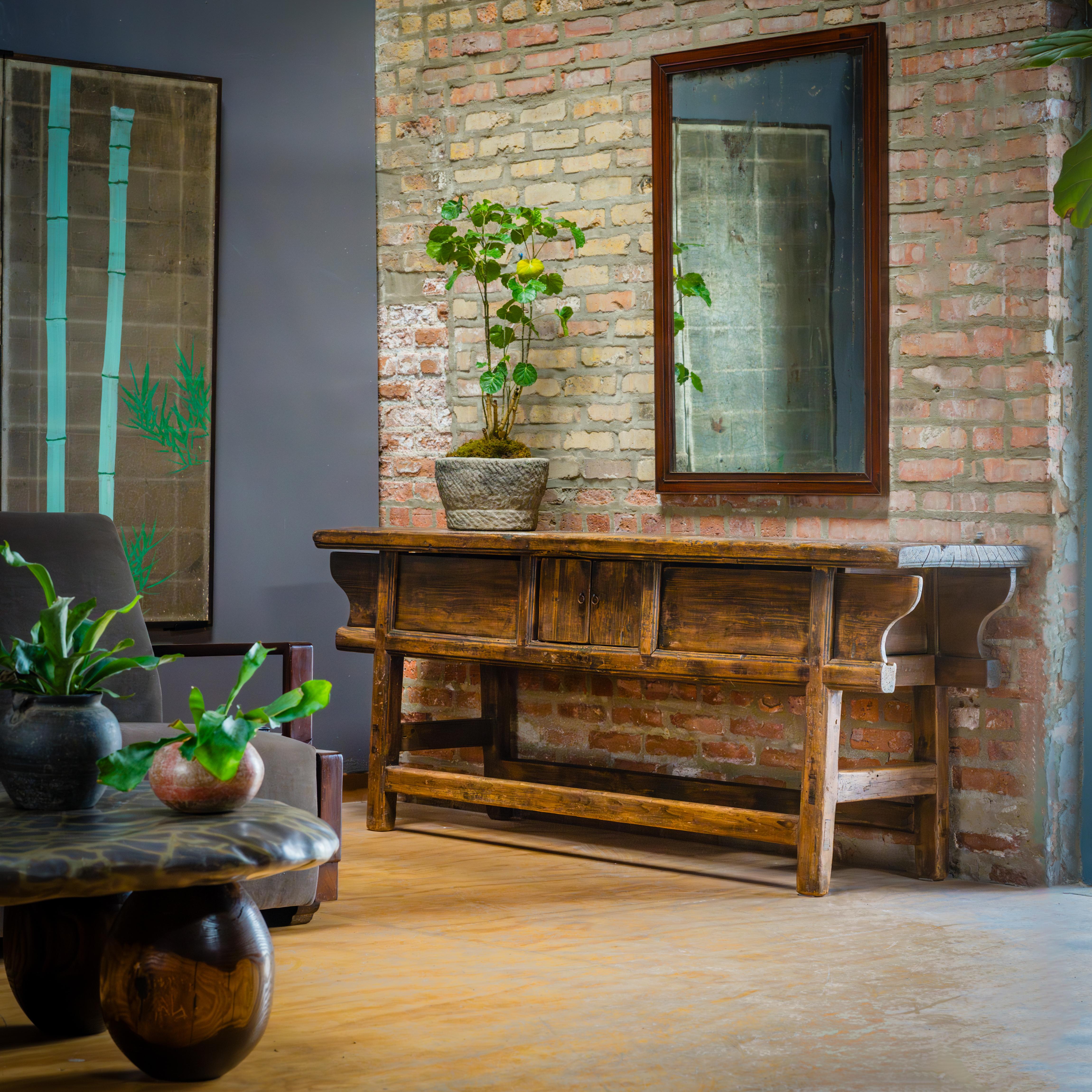 The warm tones and active grain of natural pine wood are the focus of this unusually articulated Dongbei table. Made for a provincial home in northeastern China, this table was once used to honor loved ones past and present with photos or other