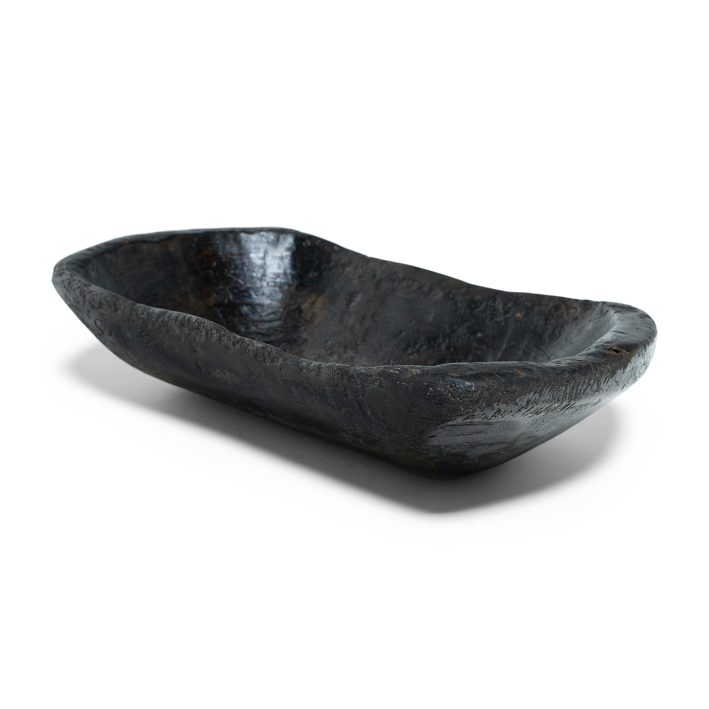 This hand-carved wooden tray from northern China charms with rustic texture and simple form. Years of use have rounded the edges and imparted a well-worn, wabi sabi texture. Originally used in a provincial farm or kitchen, the tray brings a touch of