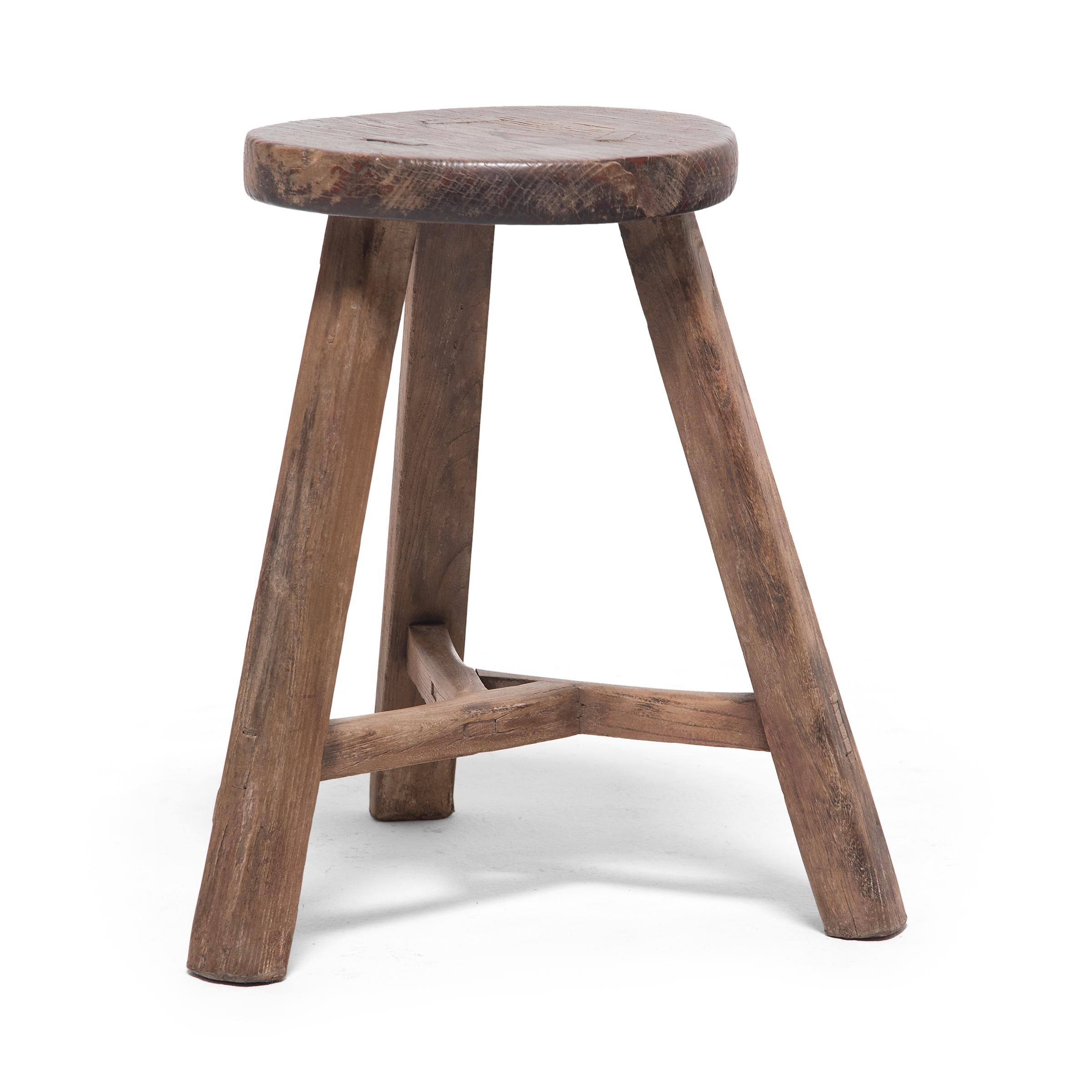 Deceptively simple, this early 20th century stool from Hebei province shows off the ingenious joinery methods traditionally used by Chinese carpenters. The stool's three splayed legs are supported by stretcher bars that interlock at the center to