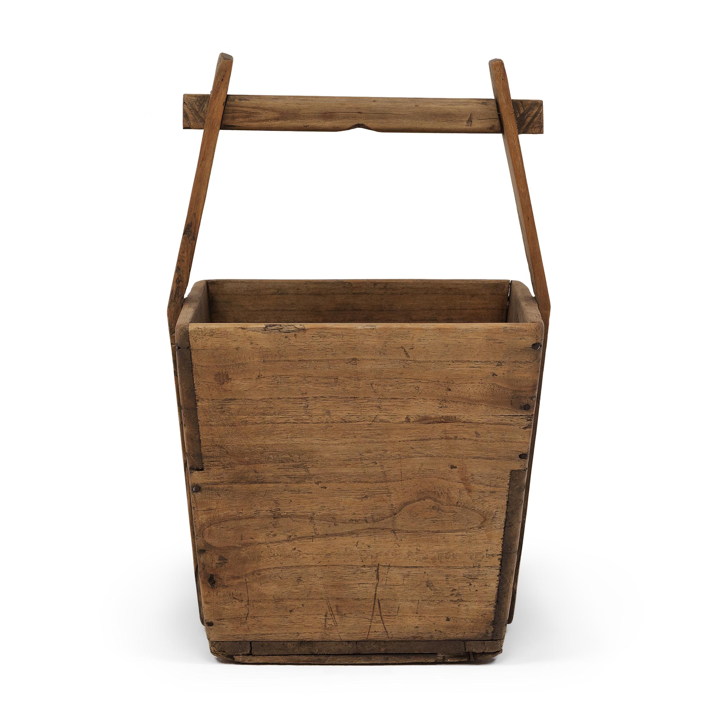 Ce seau en bois fabriqué à la main était autrefois utilisé par les agriculteurs de Shanxi, en Chine, pour transporter leur récolte de riz et de céréales sur de longues distances. Contrebalancé par un deuxième récipient, le seau était soulevé à