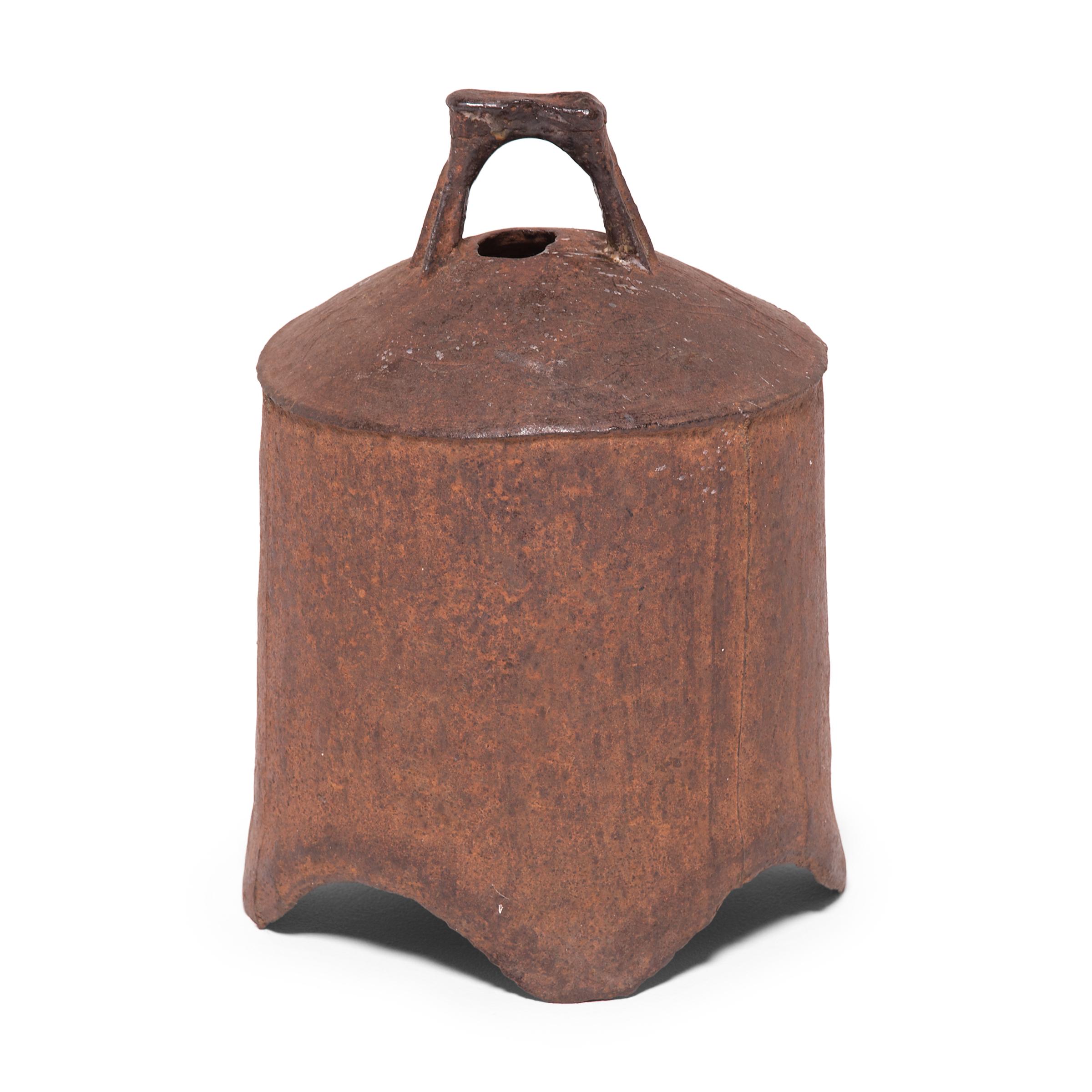 This rustic, 19th century iron bell once pealed in celebration or gave notice of important events in a town in Northern China. The shoulder of the bell is decorated with subtle linework in low relief for added texture. Marked with holes to affix a