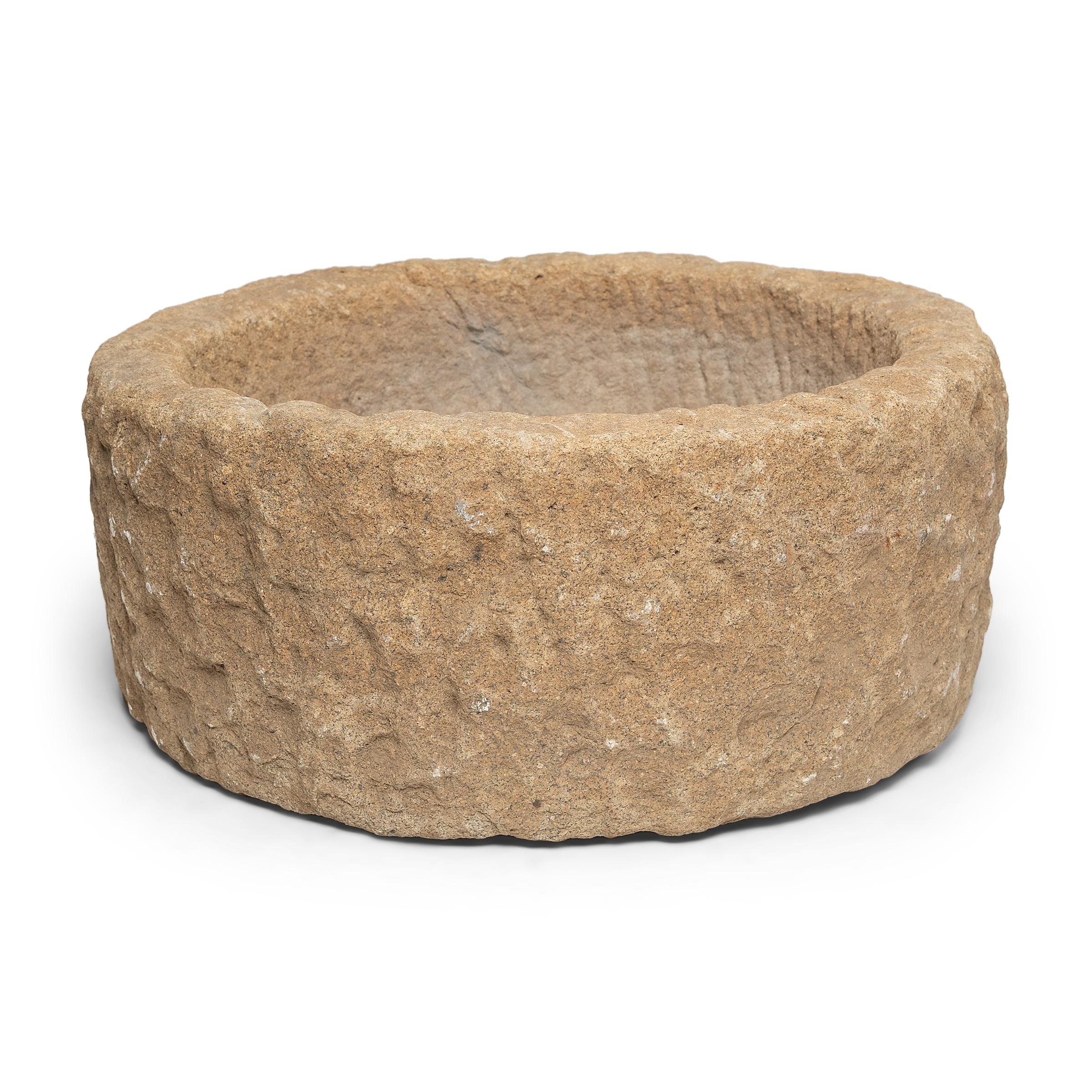 Once used on a provincial Chinese farm to hold water or animal feed, this early 20th-century stone trough is celebrated today for its organic form and rustic authenticity. Hand-carved from solid limestone, the trough has a cylindrical form with