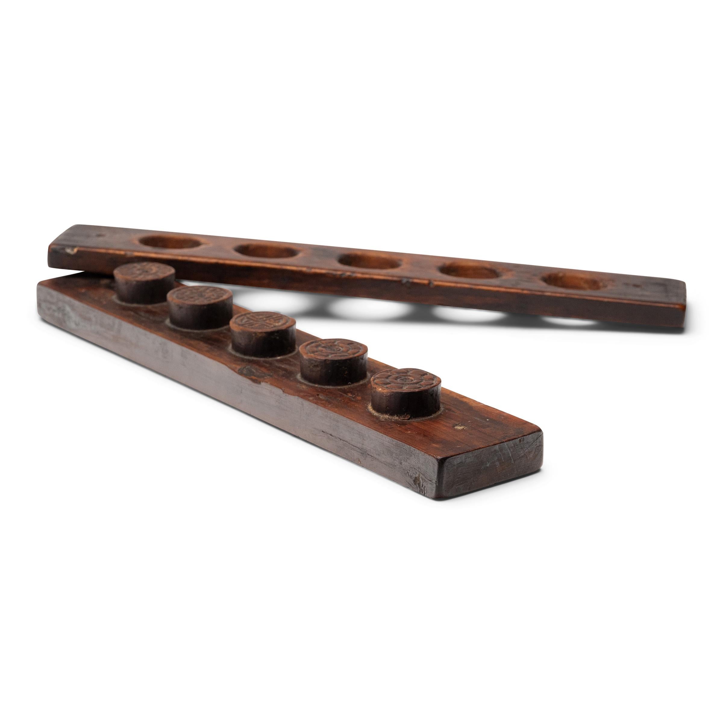 Risalente alla metà del XIX secolo, questa pressa rustica in legno è intagliata con cinque stampi rotondi utilizzati per modellare le festose mooncake. Confezionate con radice di loto, fagioli rossi o altri ripieni regionali, le mooncake sono una