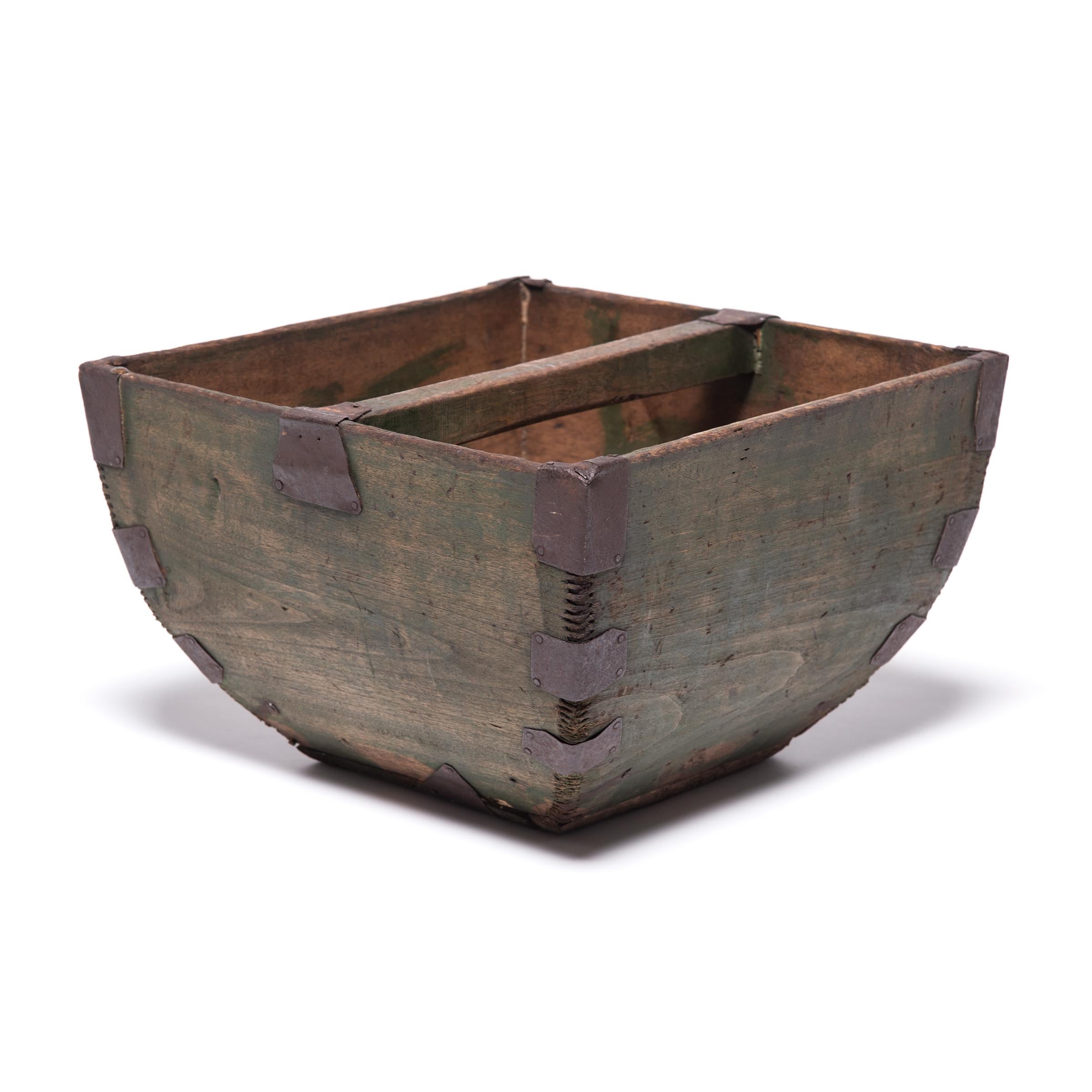 This rustic container was made over a hundred years ago to measure and hold a dou of rice, an ancient Chinese measurement. Handcrafted with dovetail joints, the vessel has gracefully swelling sides and an arched handle, burnished from years of use.