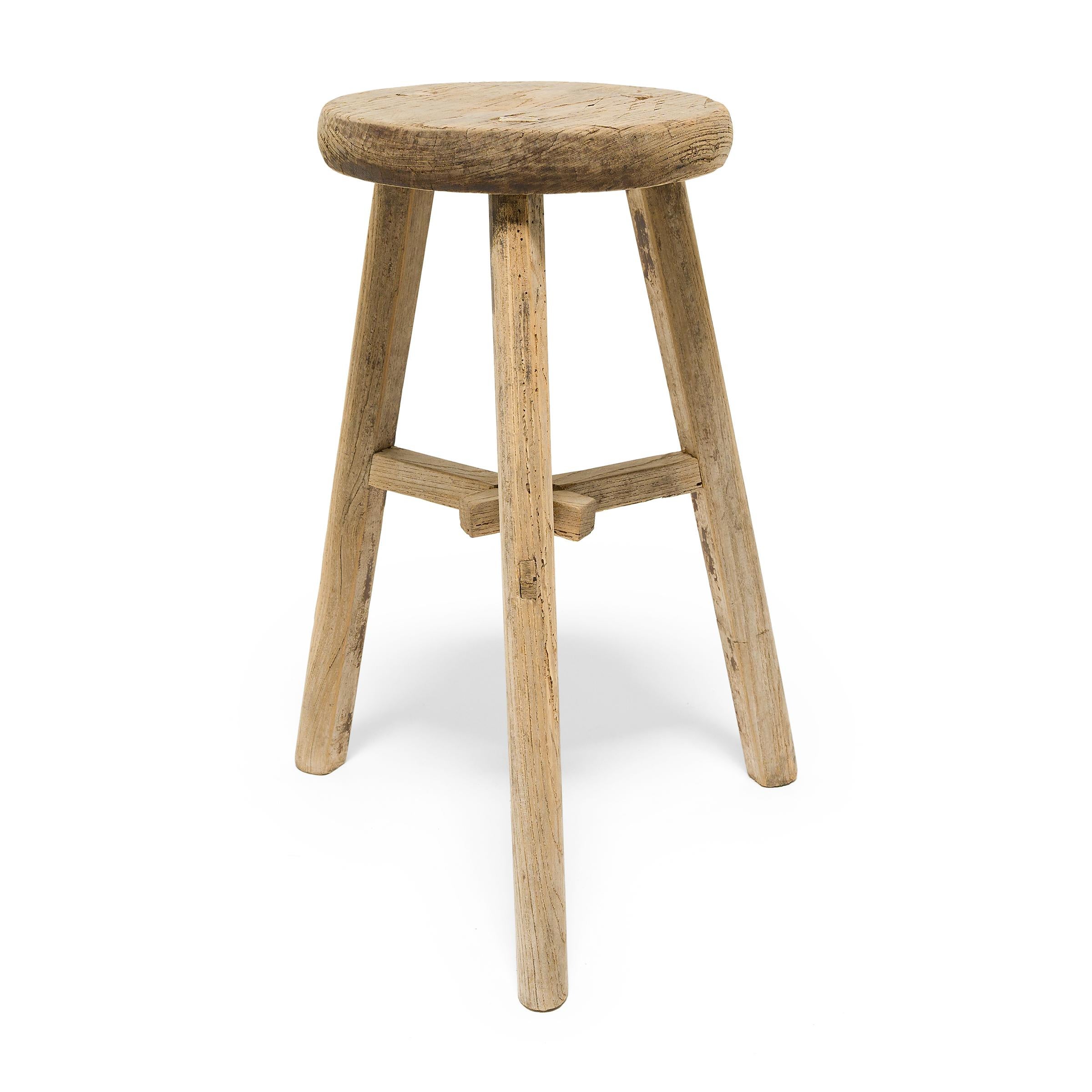 Deceptively simple, this early 20th century stool from Shanxi province shows off the ingenious joinery methods traditionally used by Chinese carpenters. The stool's three splayed legs are supported by stretcher bars that interlock at the center in a