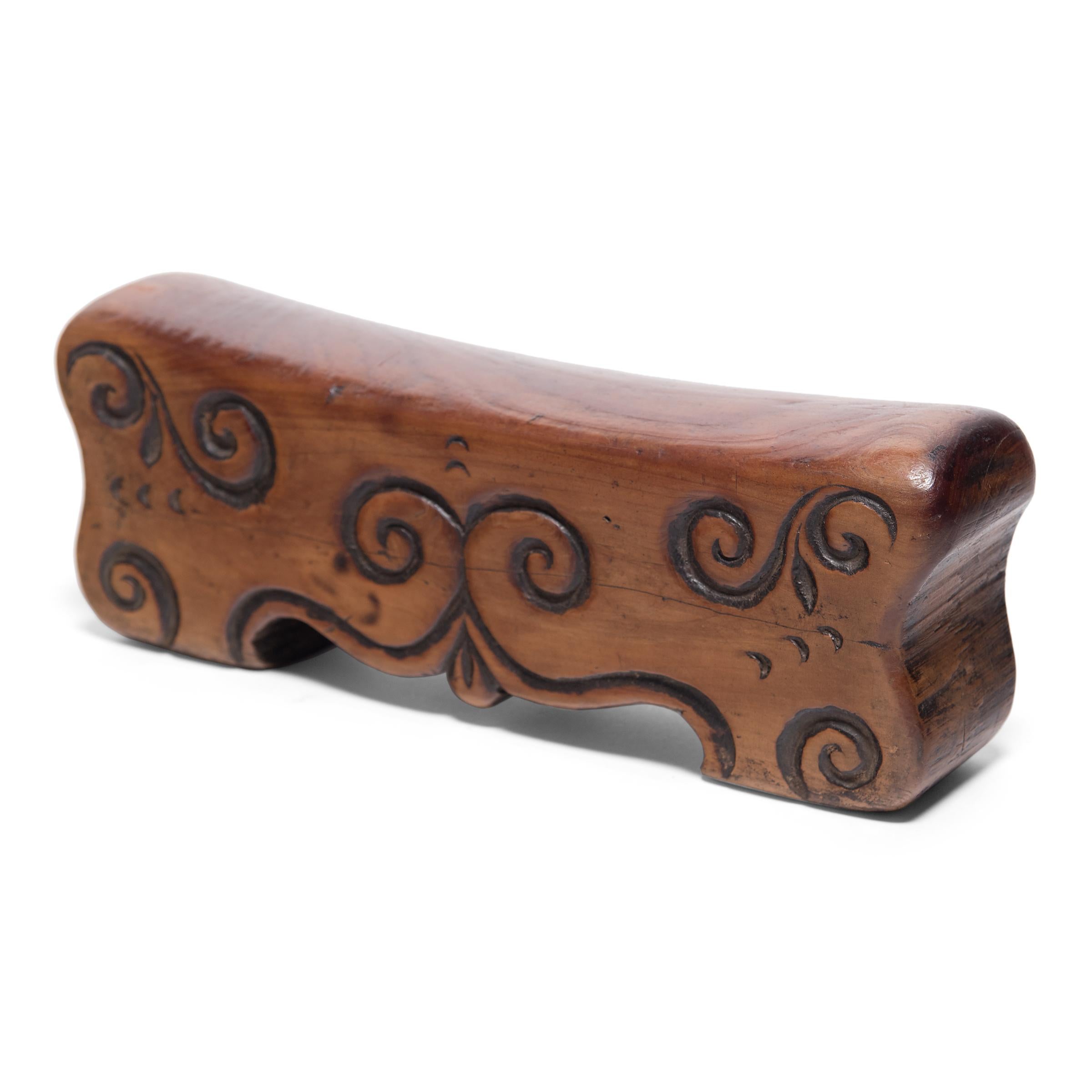 Made of Chinese northern elmwood (yumu), this smooth block of wood was once used by a well-to-do woman as a headrest. The soft curve and height of the block not only supported her head and neck at rest, it also helped to preserve her intricate