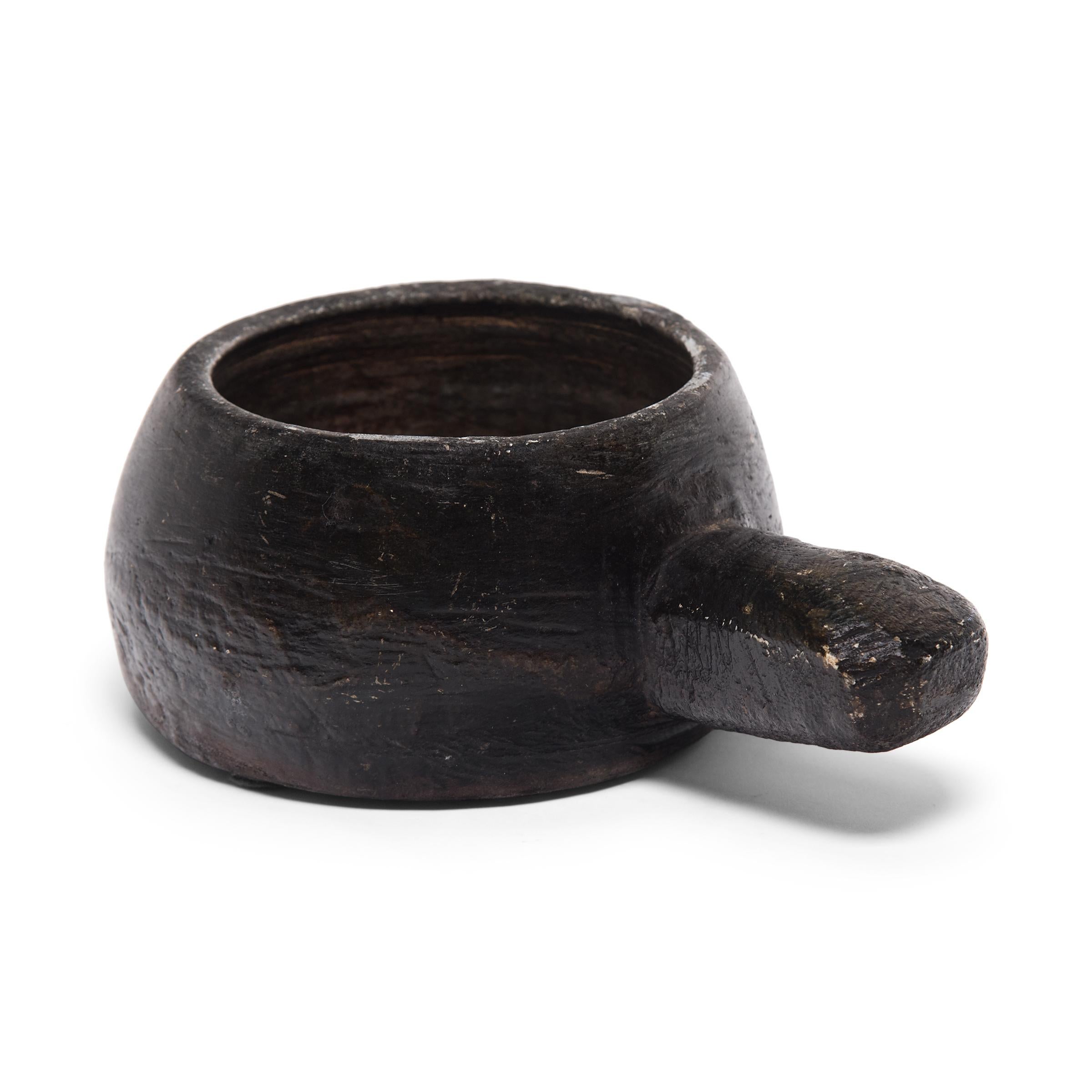 This 19th century South Korean stone mortar was originally used in a traditional apothecary. Its open bowl allowed free movement of a pestle to effectively grind, mash, and macerate herbs and seeds to prepare healing medicines. The mortar's rustic