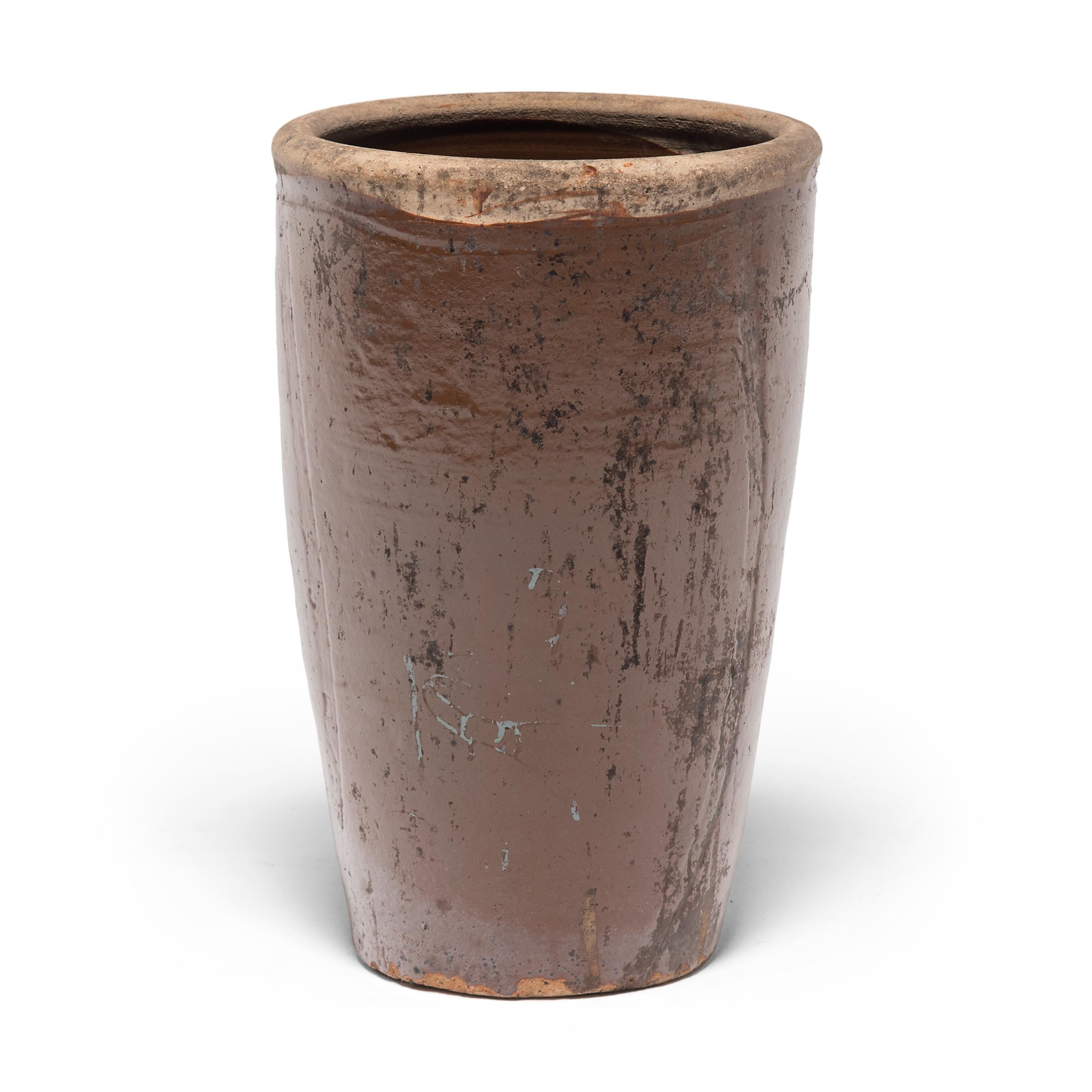 Coated inside and out with a warm light brown glaze, this monumental ceramic vessel would have been used in a Provincial kitchen to store pickled foods or keep a supply of water at arm's reach. Featuring an unglazed rim and speckled with