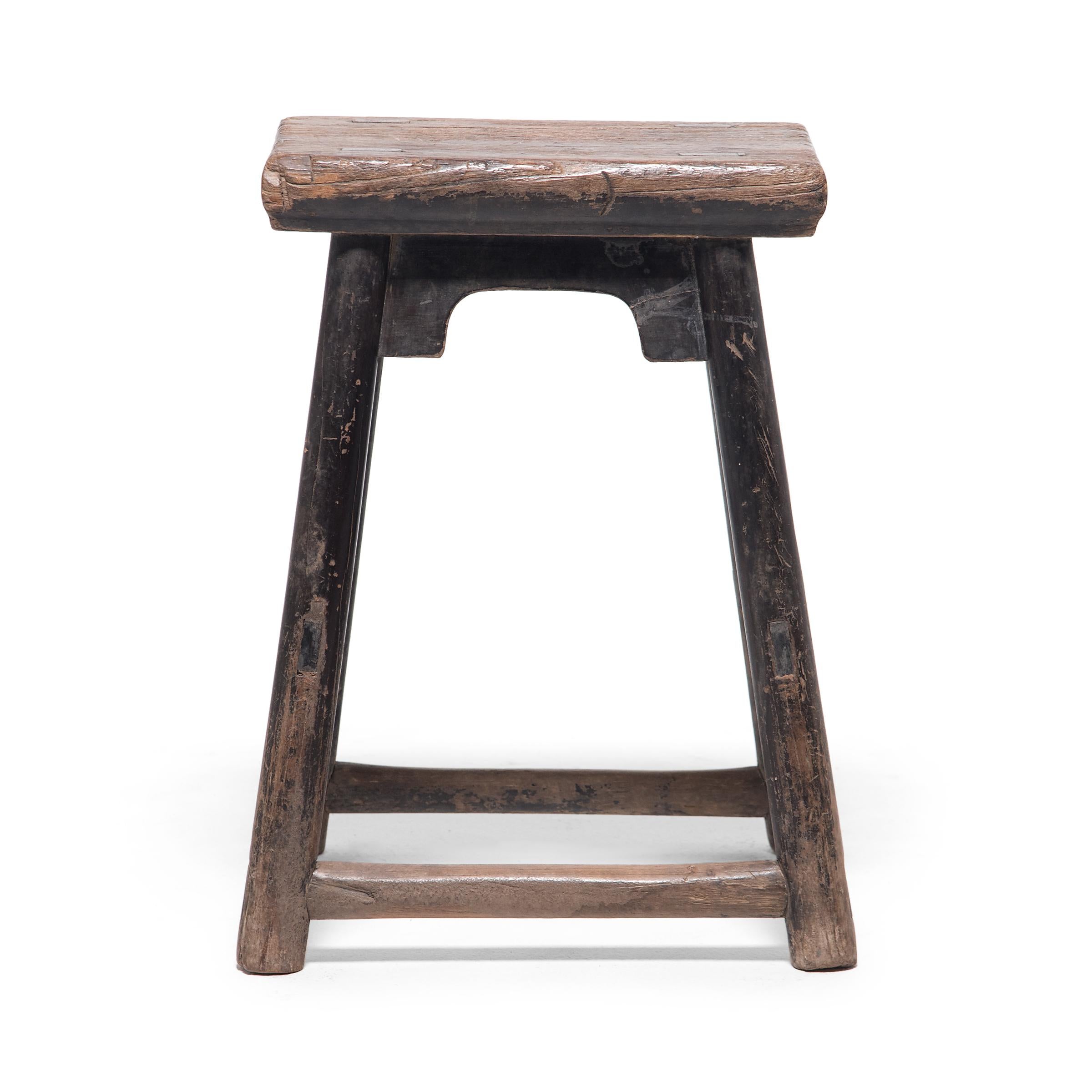 Dated to the turn of the century, this provincial stool would have been used throughout a courtyard home as versatile everyday seating. The stool has a rectangular seat supported by four round legs linked with double stretchers and simple spandrels.