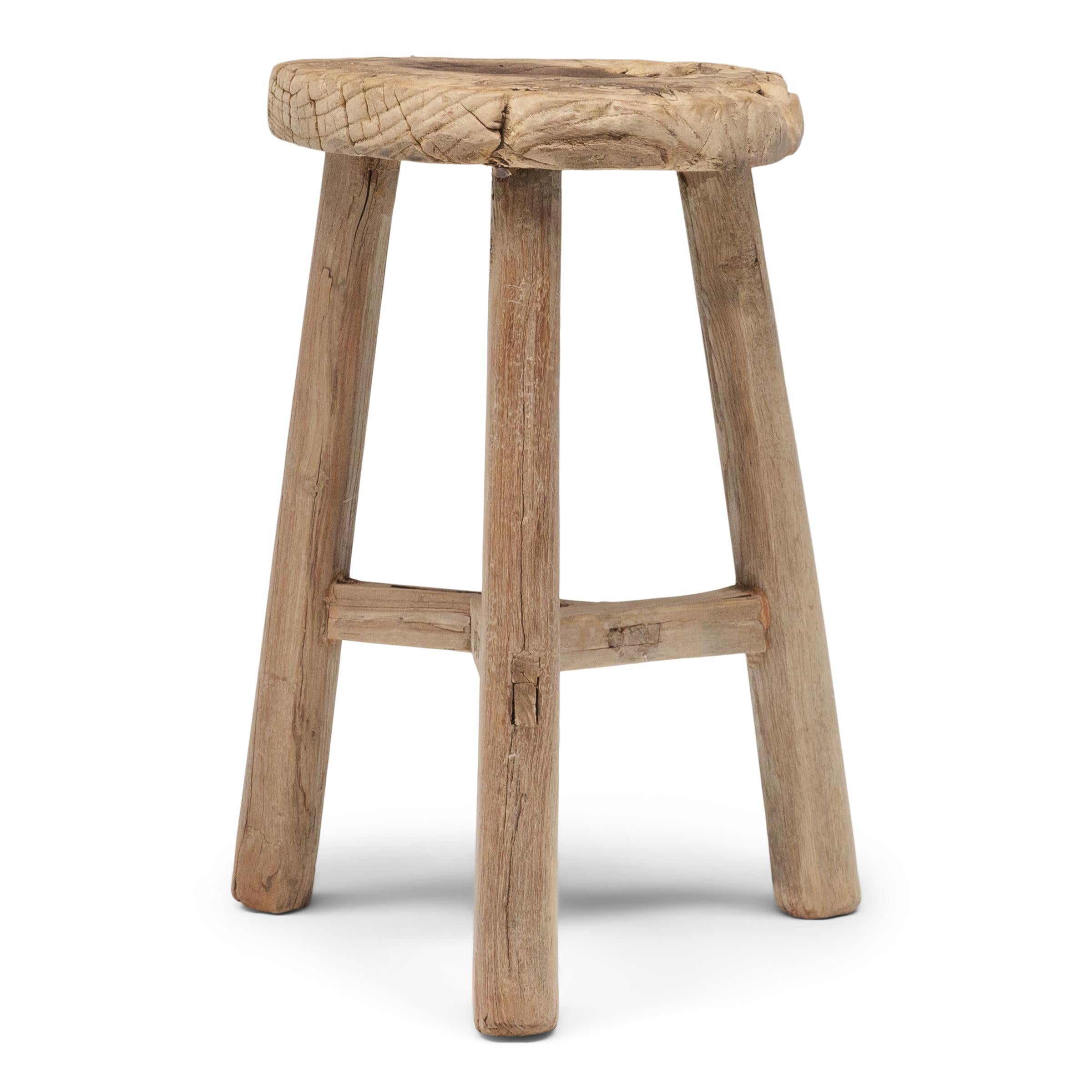 Deceptively simple, this early 20th century stool from Shanxi province shows off the ingenious joinery methods used by traditional Chinese carpenters. The stool's three splayed legs are supported by stretcher bars that interlock at the center in a