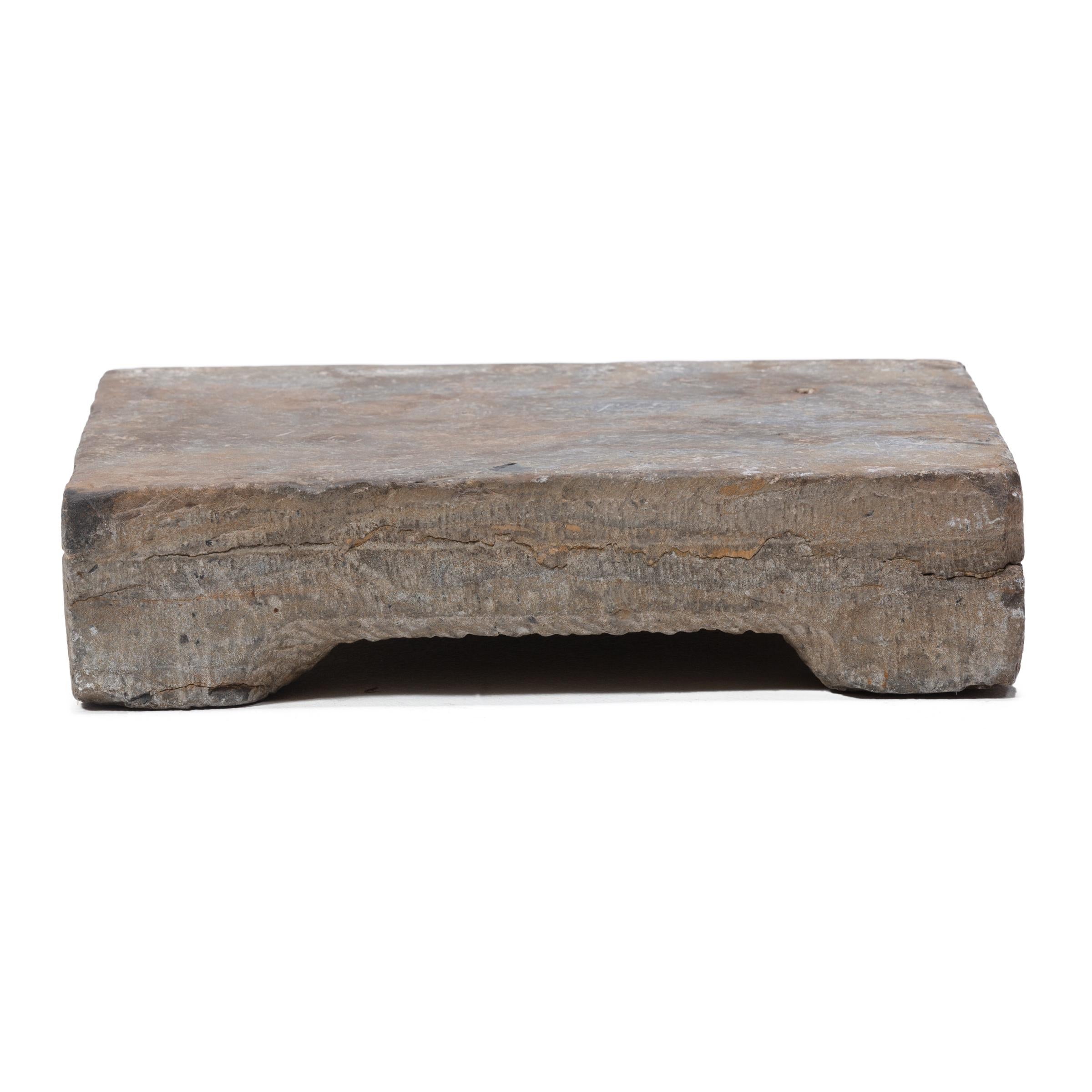 Carved in the late 19th century in northern China, this limestone washing stone would have been used by a Qing-dynasty woman for washing clothes and textiles. Used by beating wet fabrics against its smooth surface with a wooden washing stick,