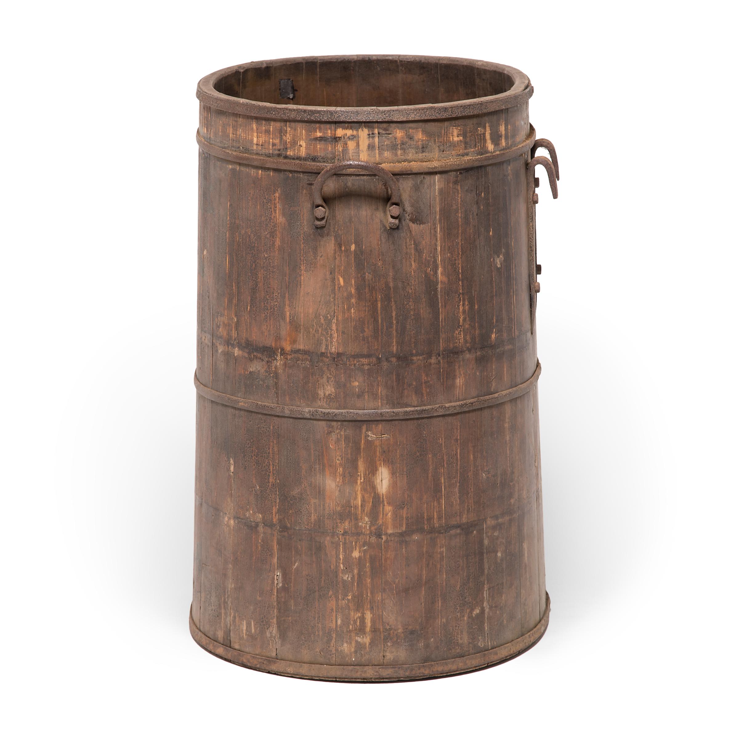 The beautifully aged surface of this Provincial water barrel is a testament to time and use. The barrel's finely joined wooden slats are held together by hand-smithed iron bands and cloaked in a layer of lacquer with a crackled finish. Chinese