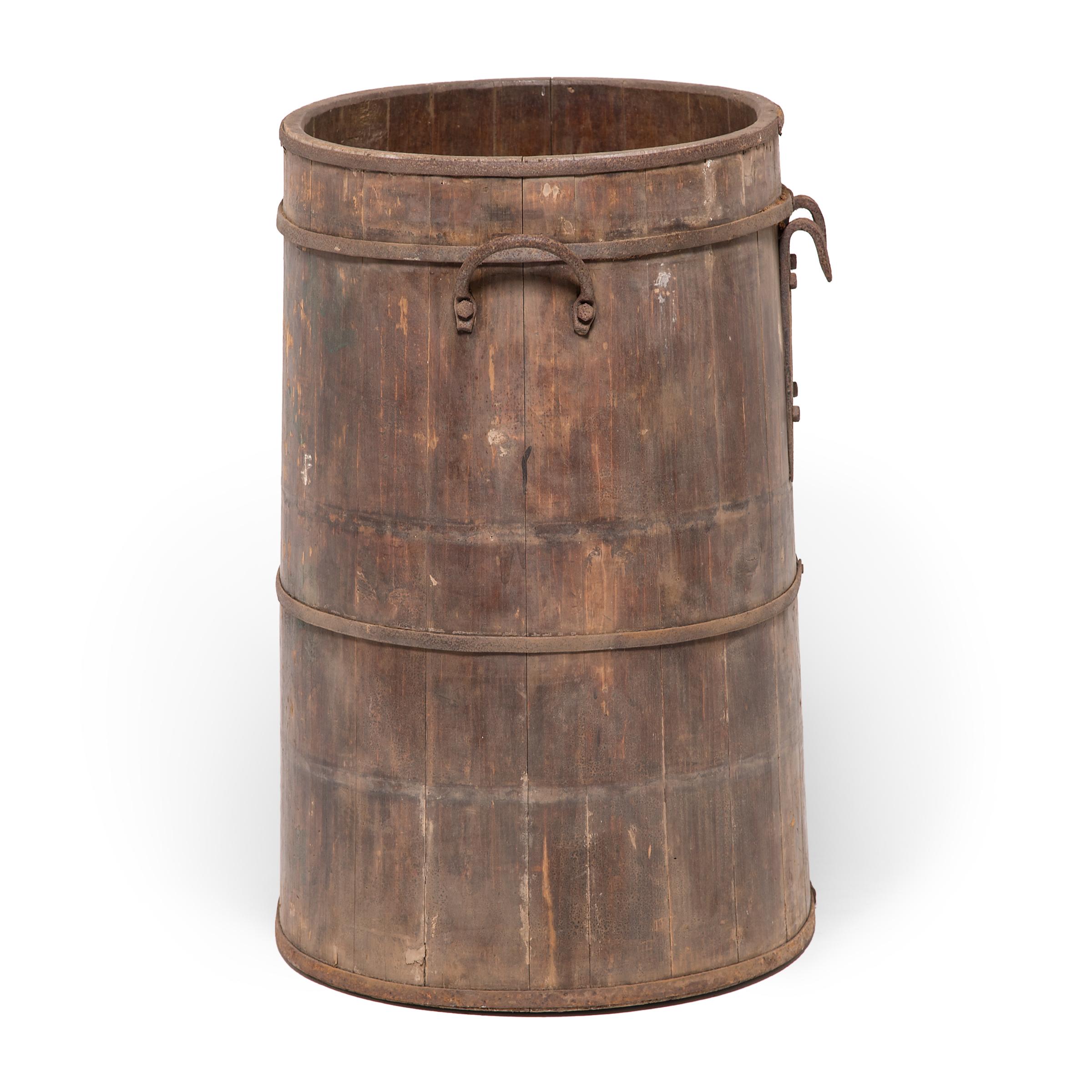 The beautifully aged surface of this Provincial water barrel is a testament to time and use. The barrel's finely joined wooden slats are held together by hand-smithed iron bands and cloaked in a layer of lacquer with a crackled finish. Chinese