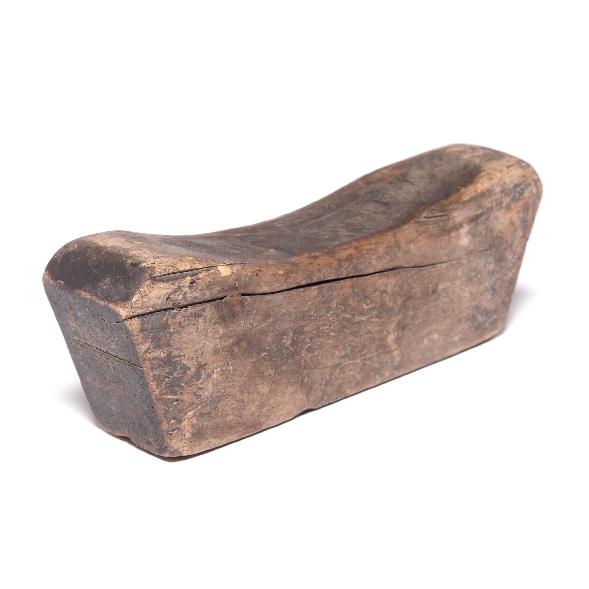 Made of Chinese northern elmwood, this smooth block of wood was once used as a rigid headrest or neck pillow. The soft curve and height of the block not only supported the head while sleeping, it also helped to hold the body in good posture and