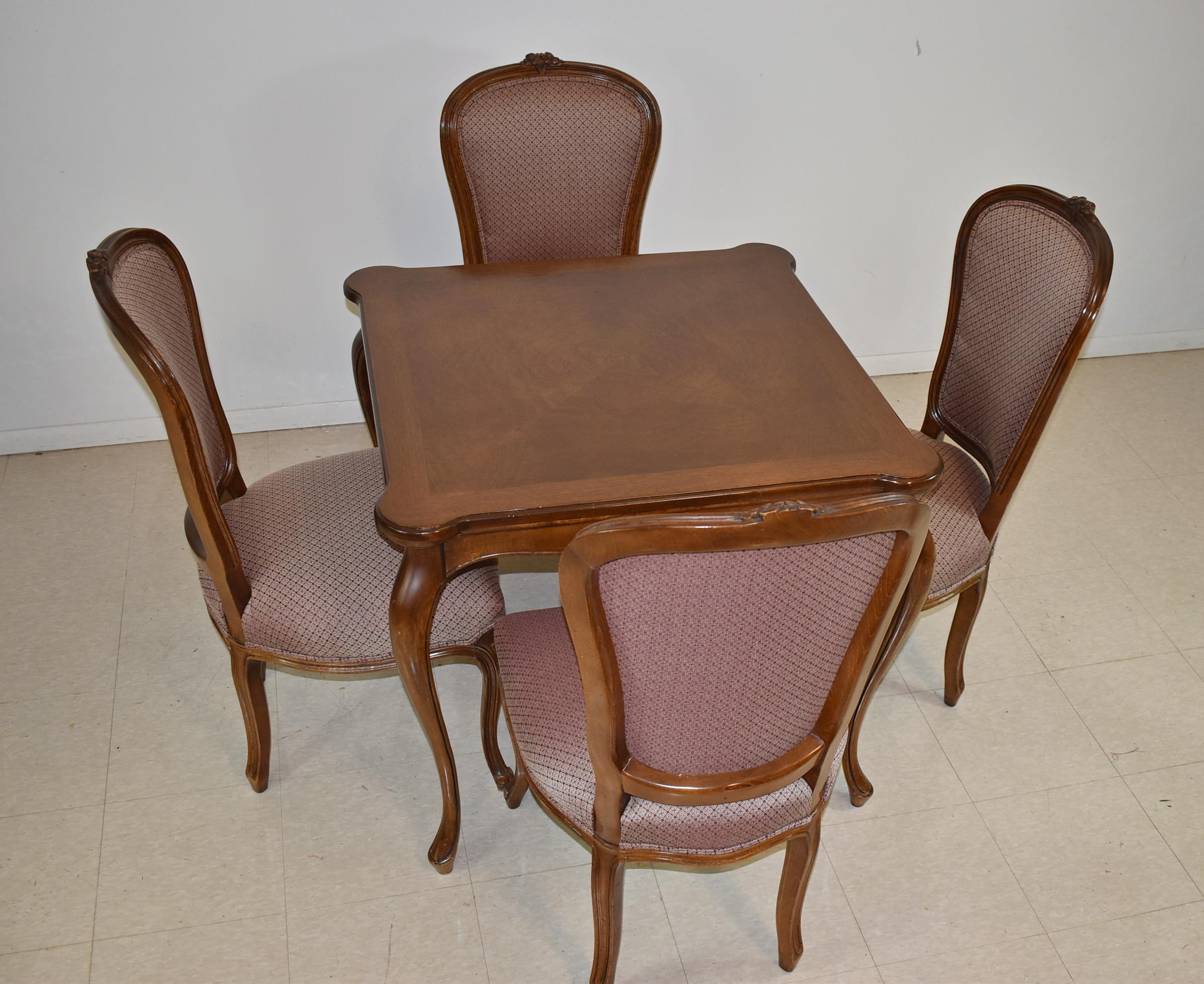 Provincial style Ethan Allen game table and four chairs. Four cup holders or hand carved floral details.