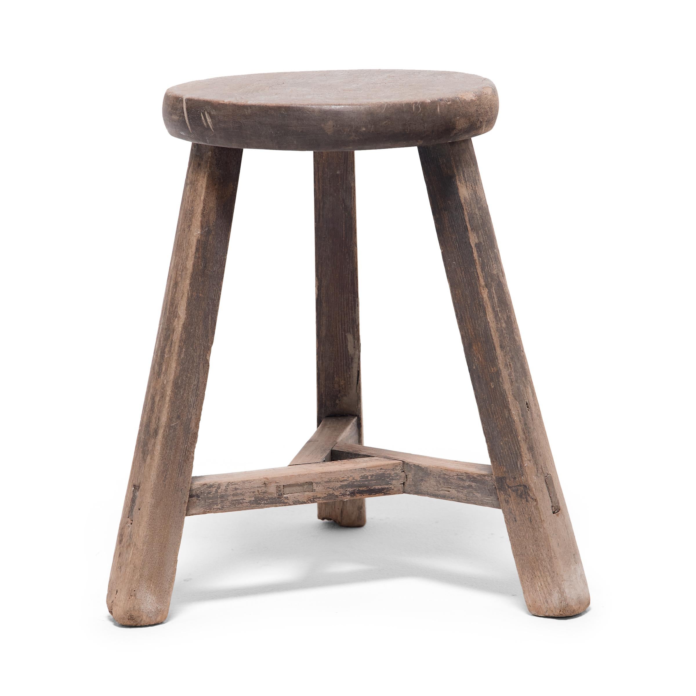 Deceptively simple, this early 20th century stool from Hebei province shows off the ingenious joinery methods traditionally used by Chinese carpenters. The stool's three splayed legs are supported by stretcher bars that interlock at the center to