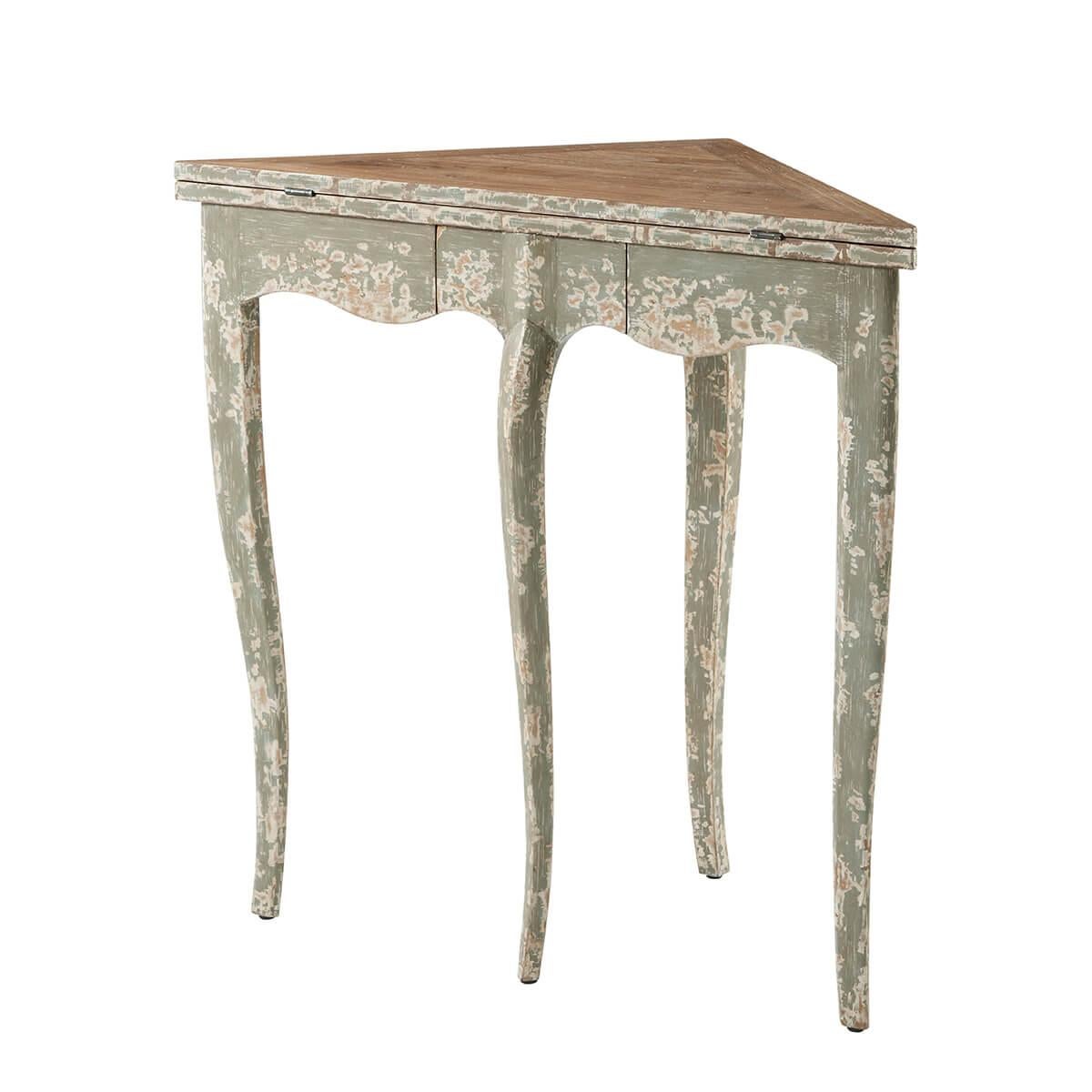 This small corner triangular fold-over hinged top game table opens to a square form table. In a hand-finished, distressed, and antiqued painted finish and raised on slender cabriole legs. 

Dimensions: 32
