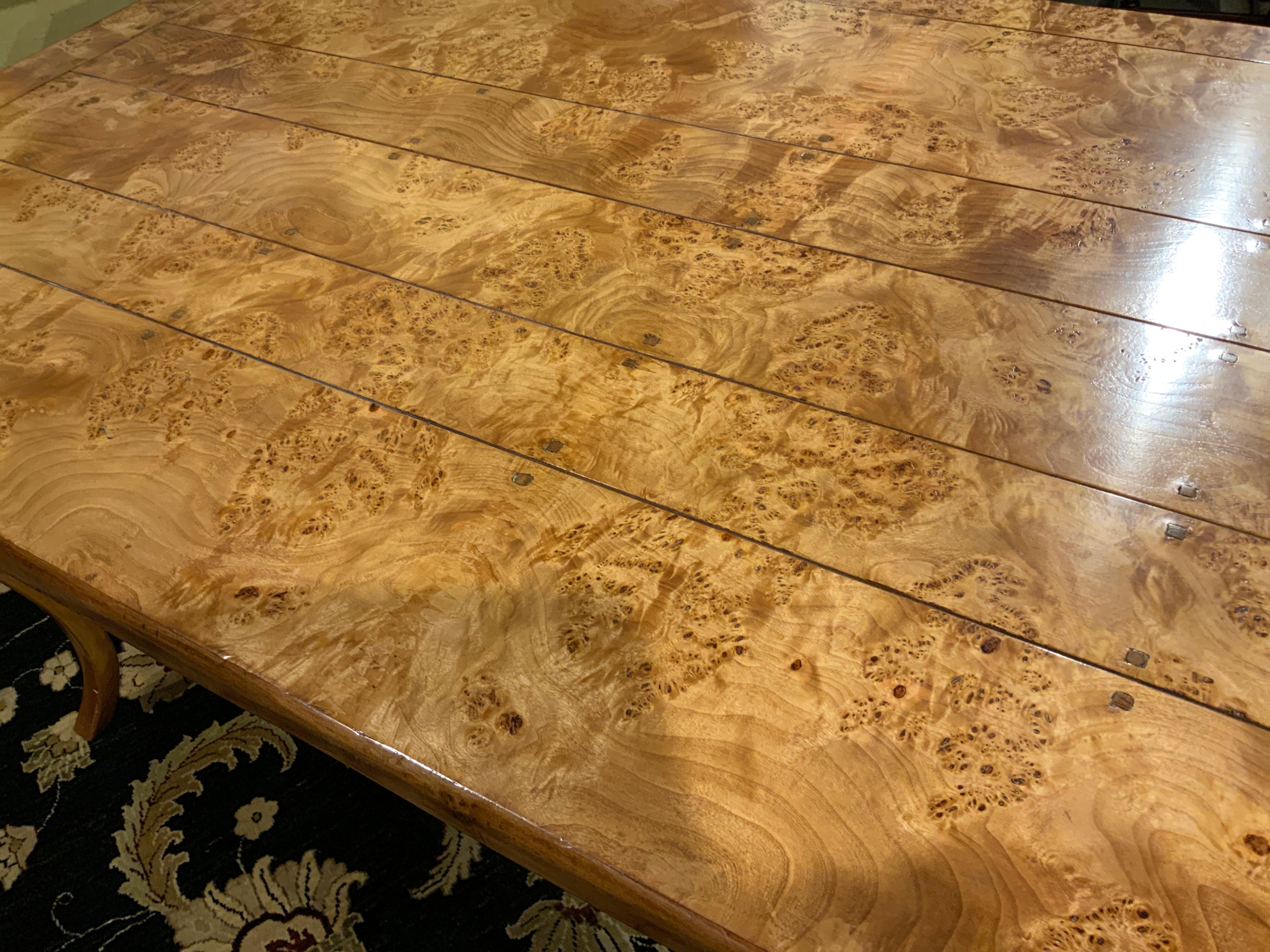 This rectangular burl elm wood top mounted to a conforming frame and raised
On shaped cabriole legs.