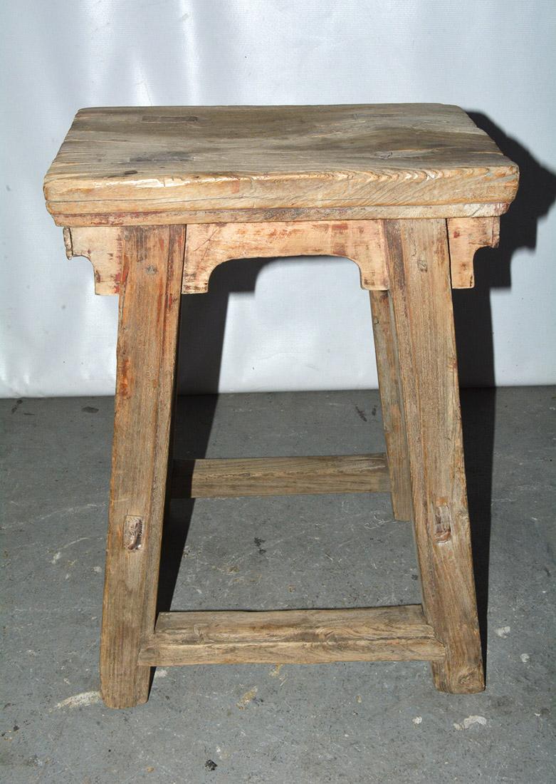 The rustic Chinese stool is crafted with pegged legs that fit into the seats and stretchers that fit into the legs for sturdy construction. The stool has a balanced form and timeless rustic appeal. Beautifully worn from a century of use, the wood's