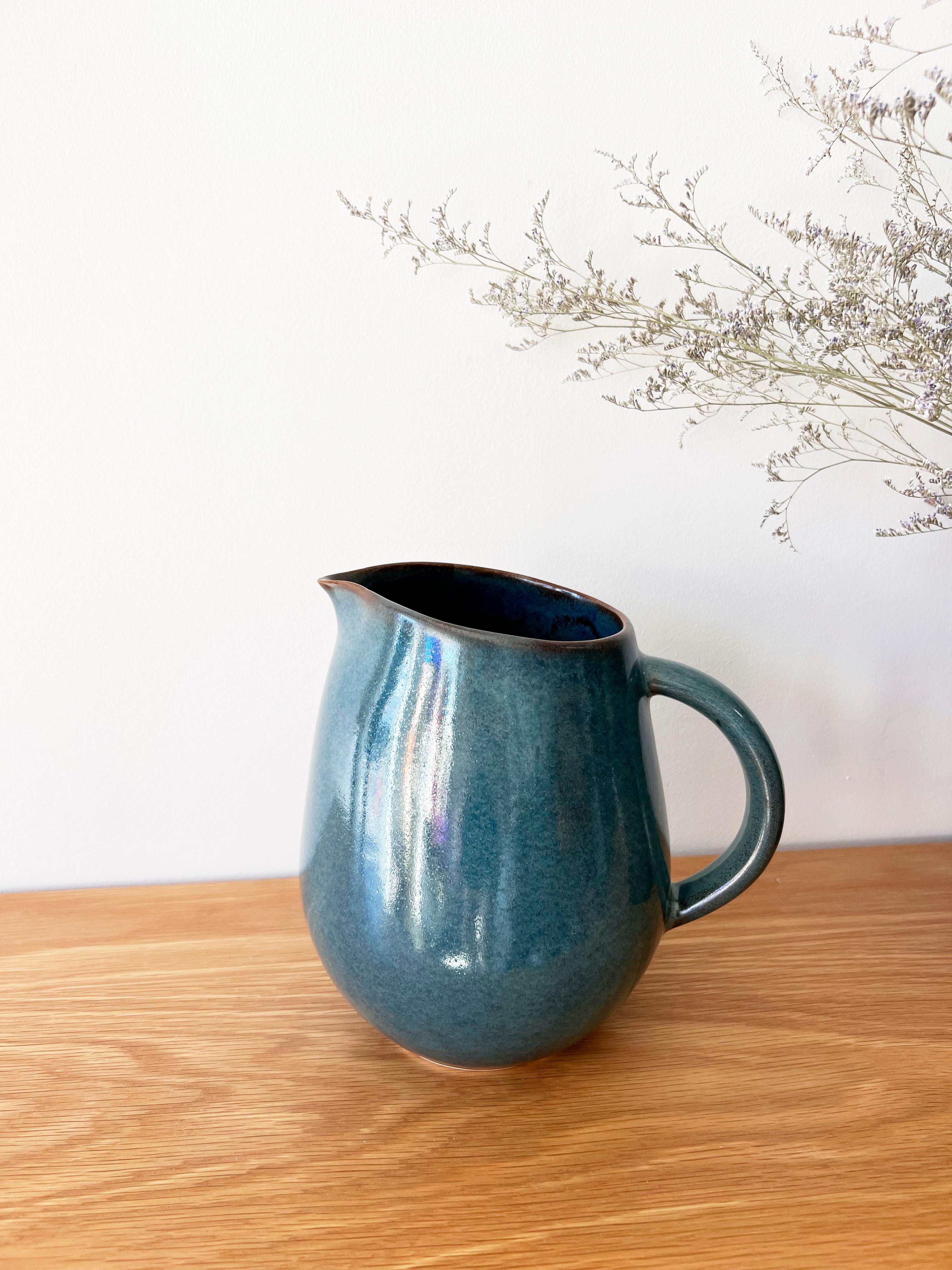 Blue glazed ceramic pitcher.

Drinks taste better when served in a beautiful vessel that has been handmade and hand glazed by artisans. Artisan made ceramics are durable and made from natural materials and can add a touch of organic modern