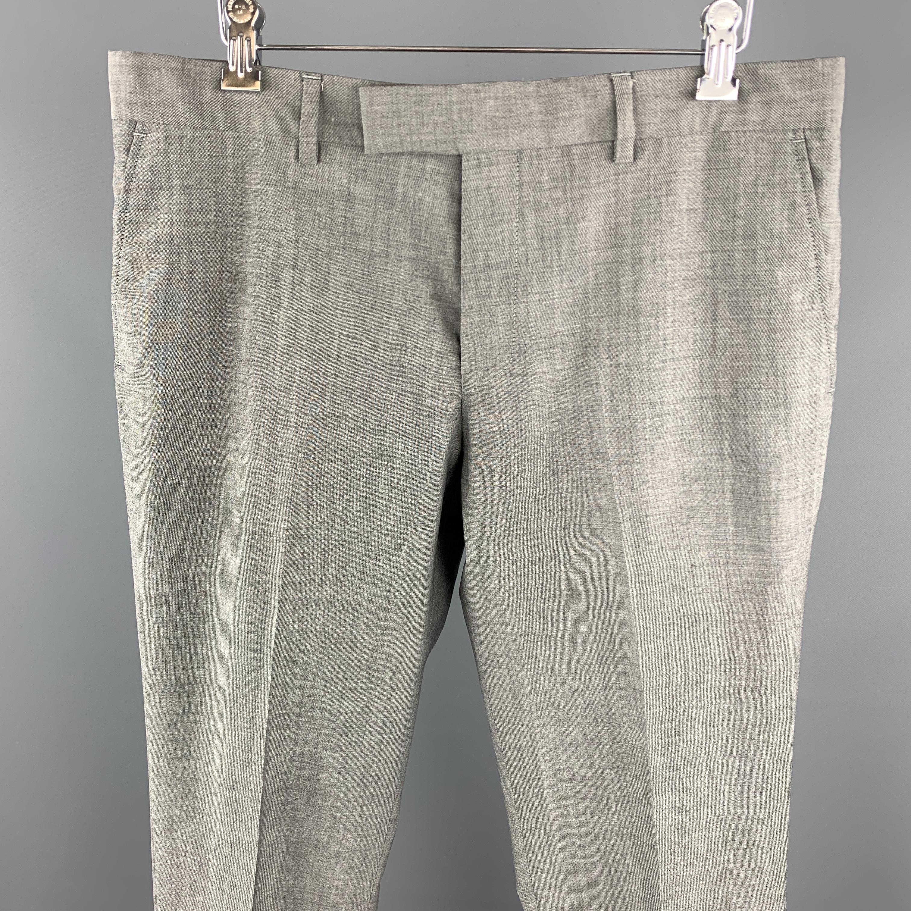 PAUL SMITH dress pants come in a light weight heathered gray wool with a flat front and tab waistband.

Excellent Pre-Owned Condition.
Marked: 32