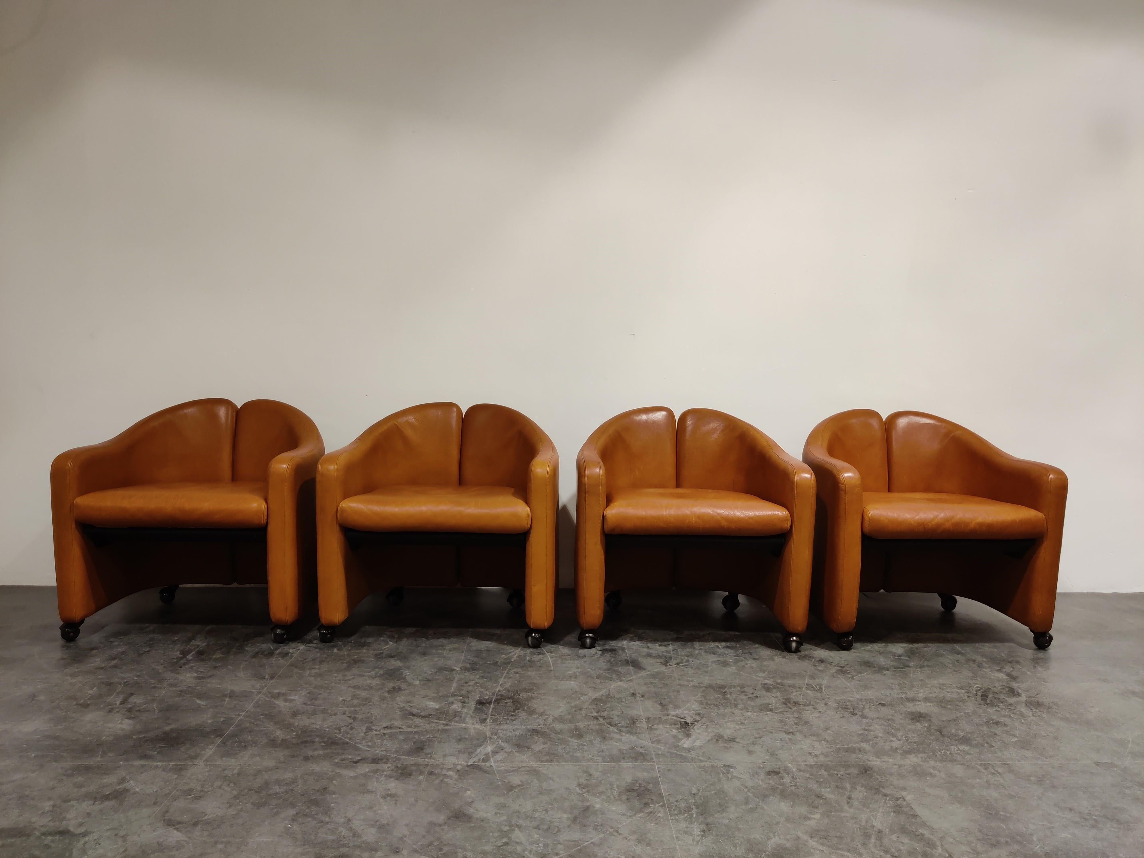Set of 4 cognac leather easy chairs model PS142 designed by Eugenio Gerlio for Tecno, Italy.

These beautiful 'split back' sit very comfortable.

Good overall condition, age related wear. No rips or cracks. One has a small spot on the seat; not