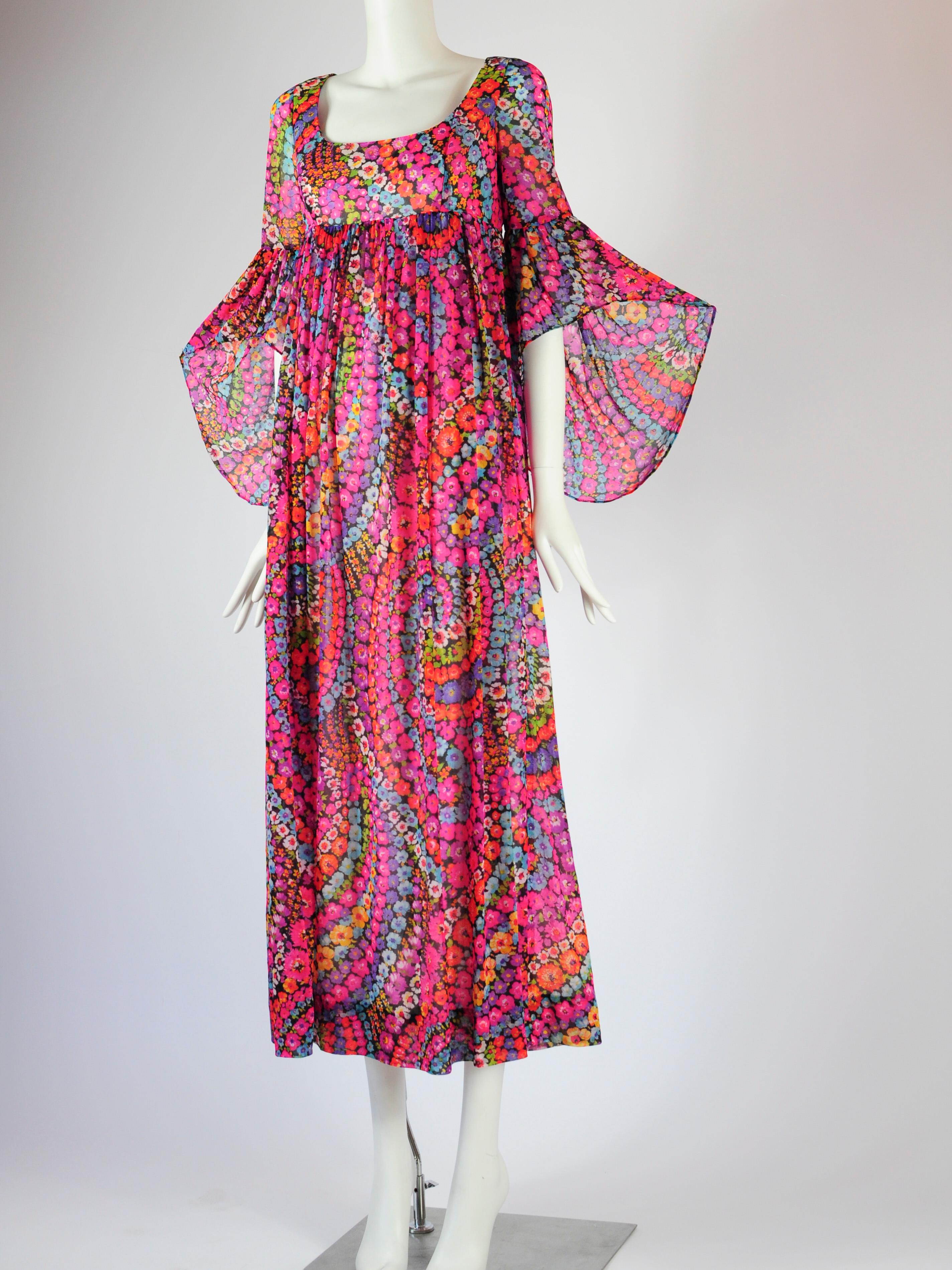Robe longue à imprimé floral psychédélique de Quad London datant des années 1970. La robe a une taille empire avec une jupe fluide, et de belles manches papillon (aussi parfois étiquetées comme manches chauve-souris ou manches d'ange). L'imprimé