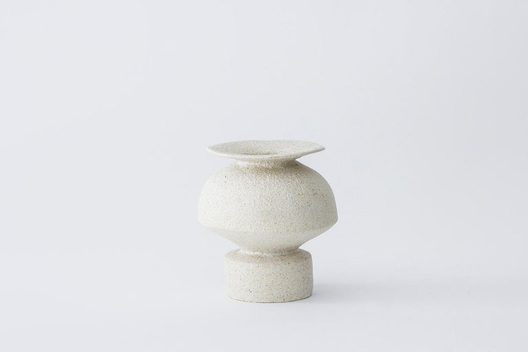 Psycter Hueso stoneware vase by Raquel Vidal and Pedro Paz.
Dimensions: 15 x 16 cm.
Materials: hand-sculpted, glazed pottery.

The pieces are hand built white stoneware with grog, and brushed with experimental glazes mix and textured surface,
