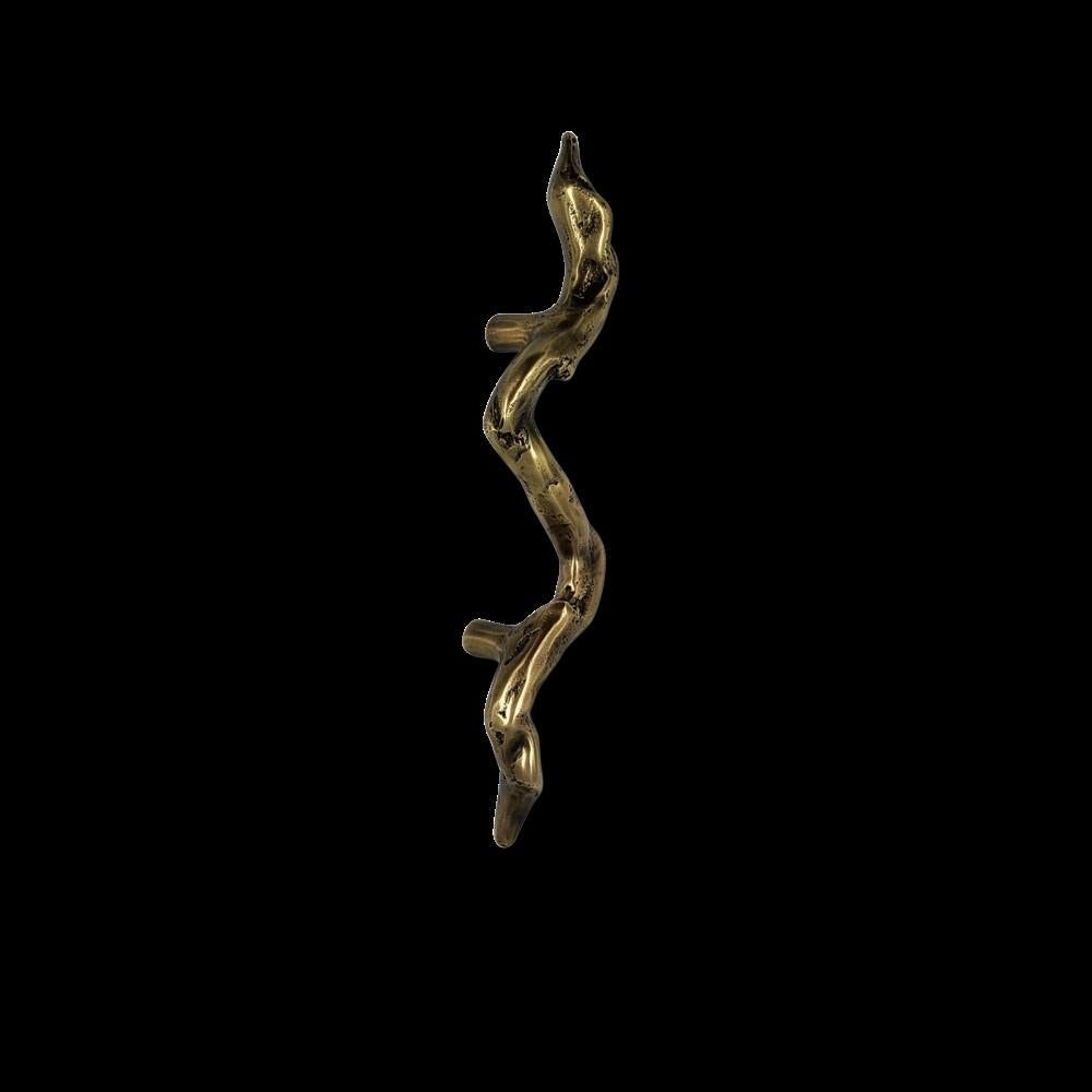 Este tirador de latón macizo, hecho a mano por artesanos expertos, se inspira en las formas orgánicas de la naturaleza. Su silueta sinuosa se hace eco de los contornos irregulares de las ramas, ofreciendo una estética cruda y natural. Forma parte de