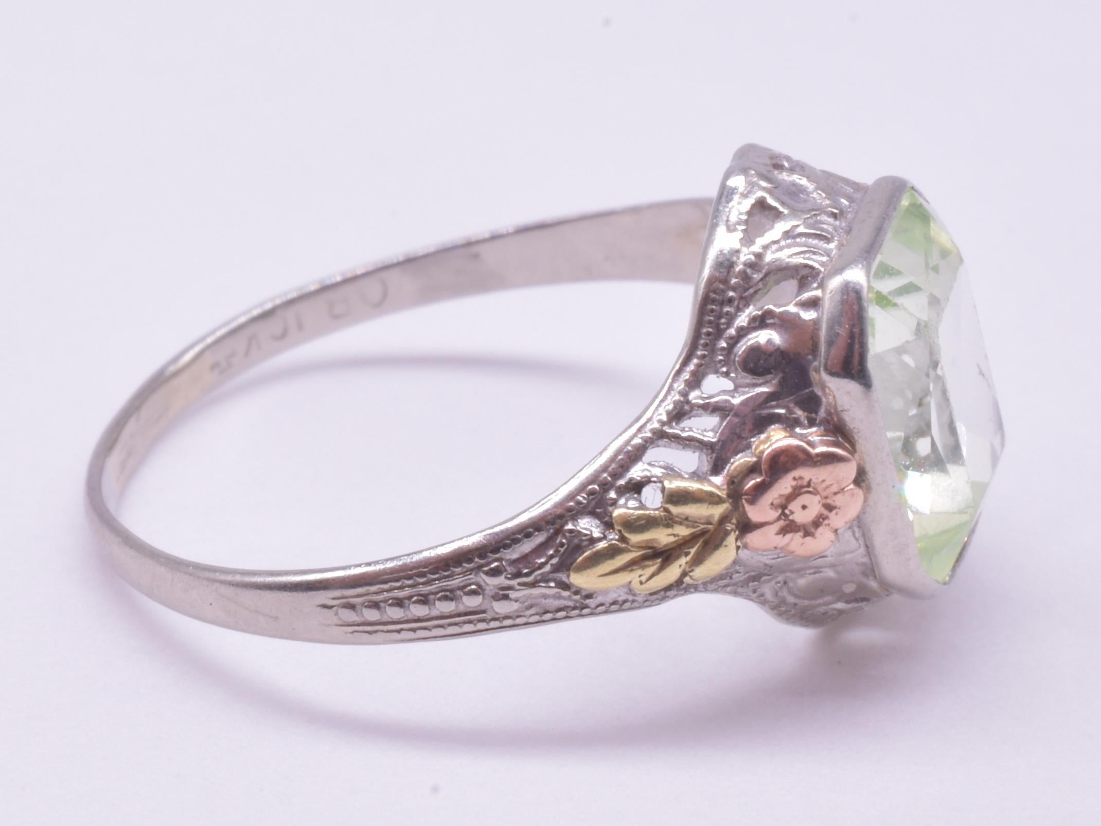 10K Ostby and Barton Ring embellished with a lovely raised 2 color gold flower and leaf along the sides and an octagonally shaped solitaire peridot that looks like a clear blue green, depending on the light. Ostby and Barton were jewelry