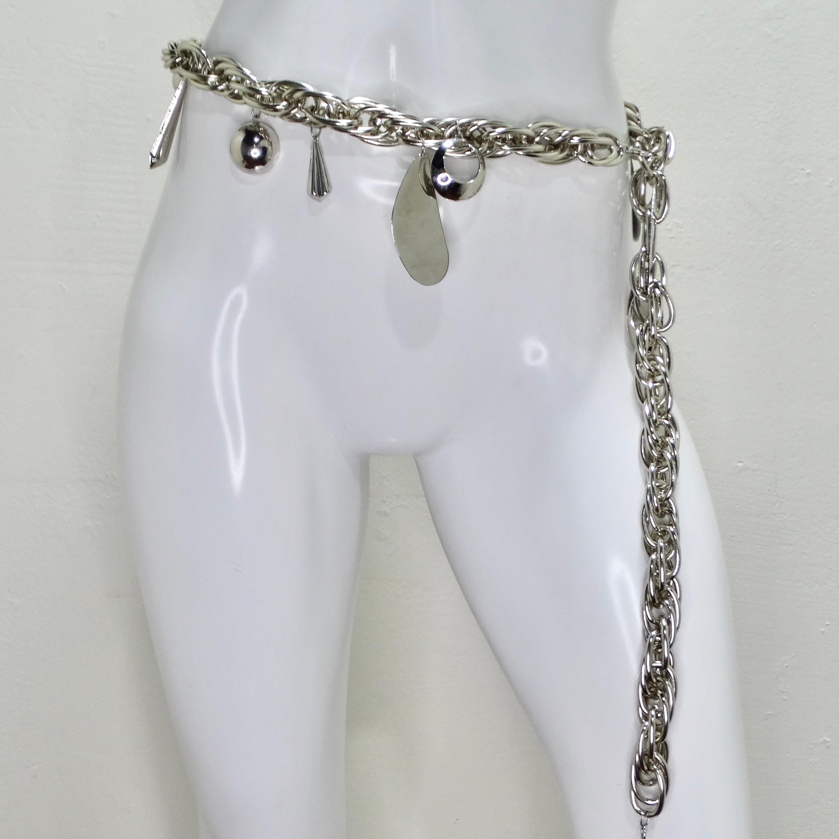 Make a bold statement with the , a true testament to the era's avant-garde fashion. This incredible belt features a double silver-tone chain adorned with a variety of mirror-effect geometric dangling charms, each adding a touch of glamour and