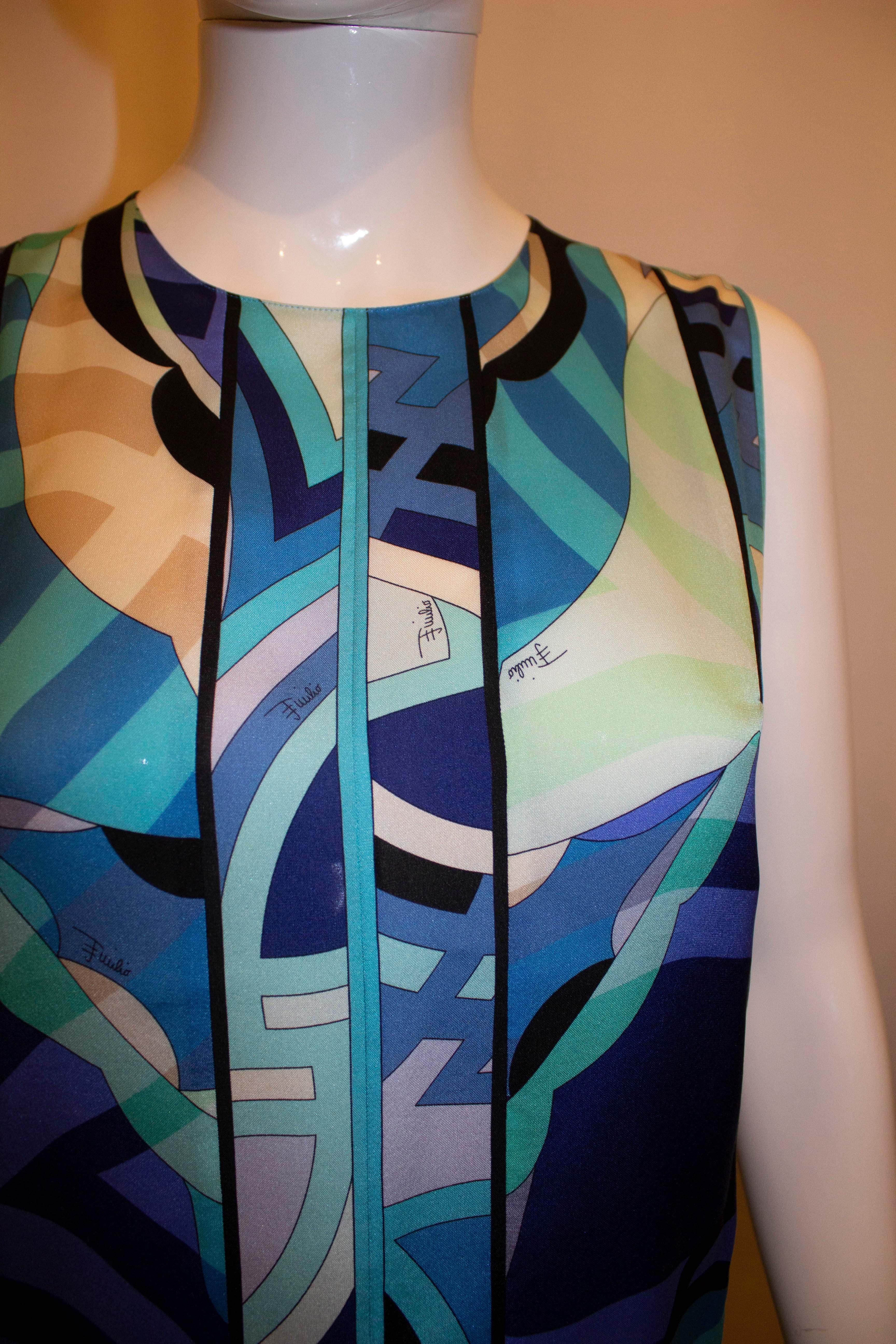 A pretty vintage silk shell top by Pucci. The print is in several shades of blue, and the top has a round neckline with back button opening with a silk covered button. 
Measurements: Bust up to 37'',length 24''