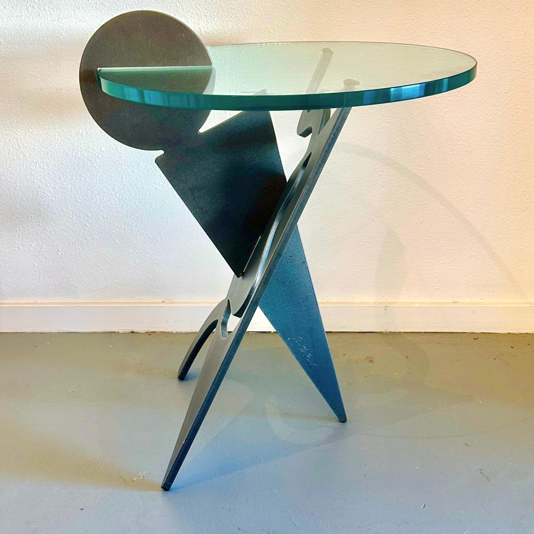 Pucci De Rossi for H Dolin Stuart Signed Battista Occasional Table, 1987

A delightful postmodern sculptural side table with an interlocking charcoal color metal base with glass top by Italian-born, Paris-based designer and artist Pucci de Rossi.