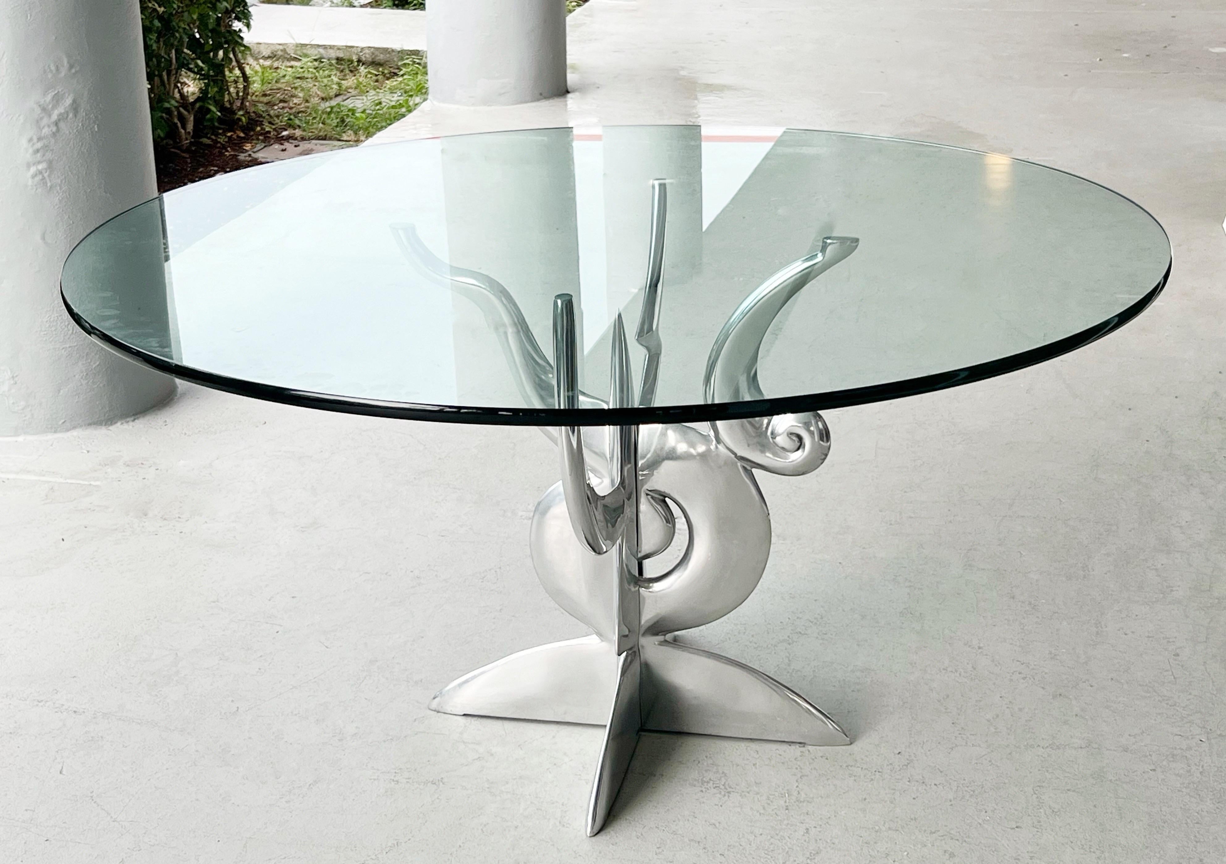 Une table de salle à manger de Pucci de Rossi. La base est composée de deux pièces sculpturales imbriquées en aluminium poli et d'un plateau en verre de 3/4