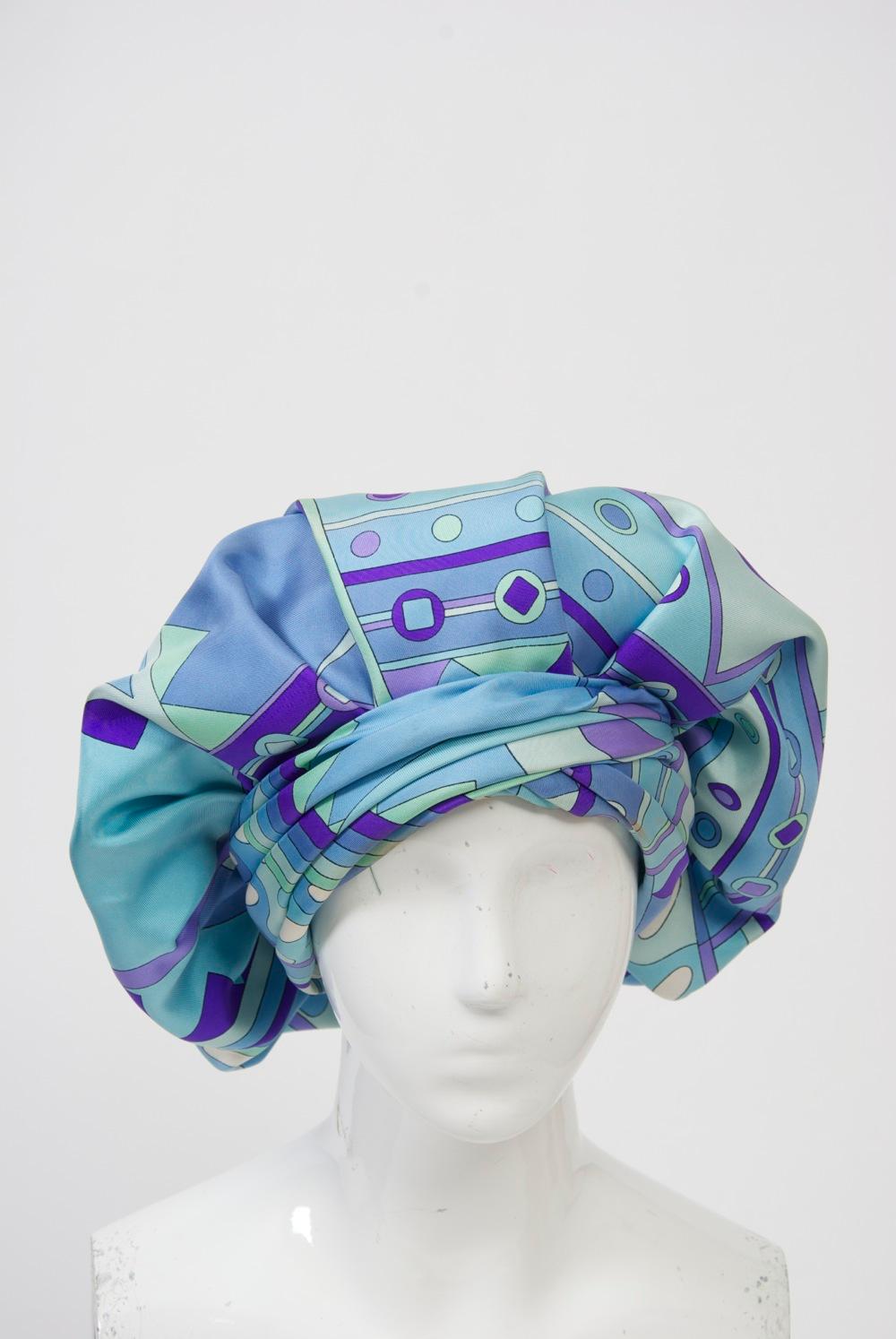 Custom-made hat crafted of Pucci blue/purple silk print in an expanded beret style featuring a pleated turban-style band that circles the head. Emme was a high-end New York millinery, known especially for its custom hats. From 1952-62, Adolfo was