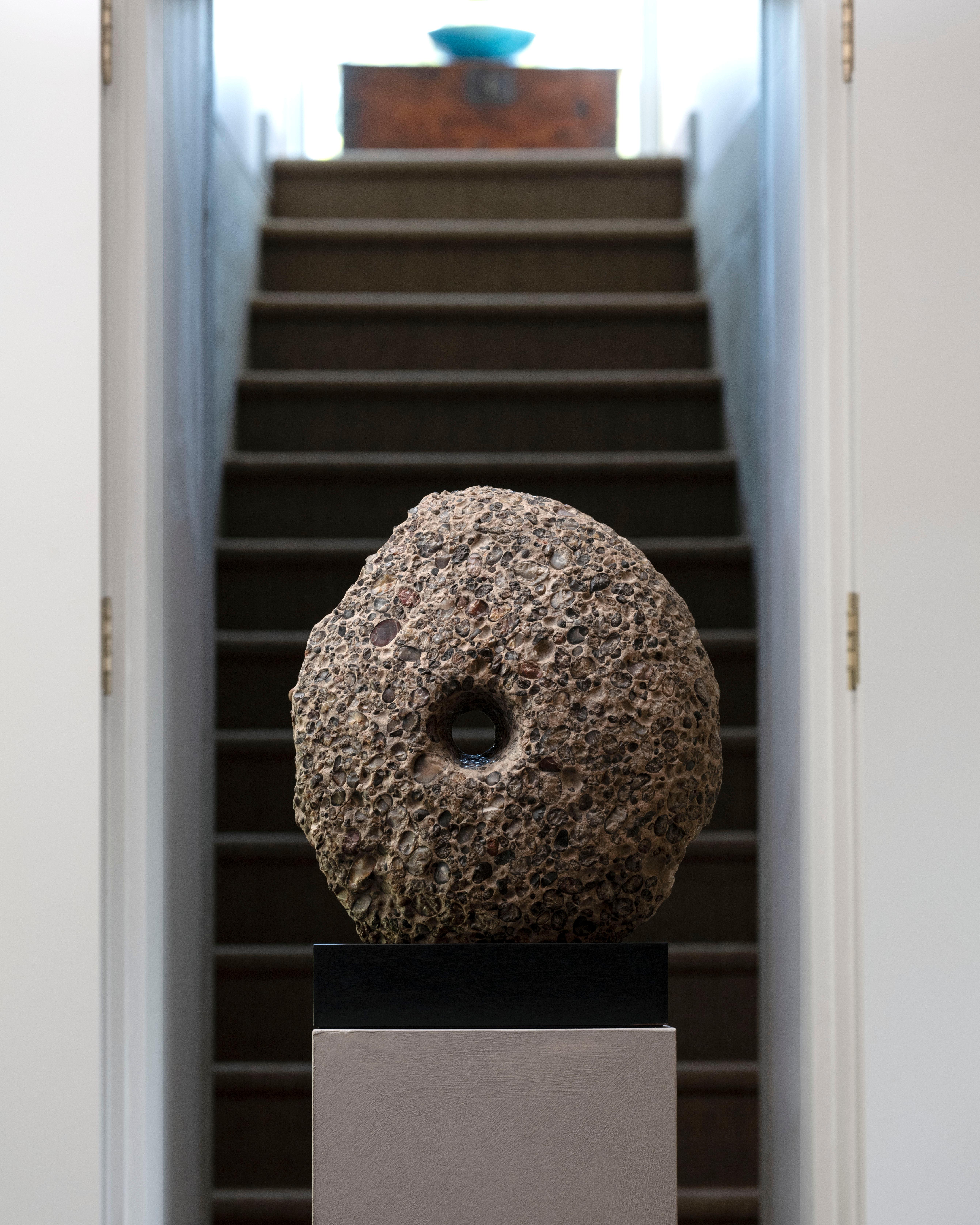 Carved from a mosaic-like rock, this striking sculpture is the lower grinding stone from a Gallo-Roman millstone - a powerful and aesthetic symbol of life two millennia ago. It is made from puddingstone, an extremely beautiful and hard sedimentary