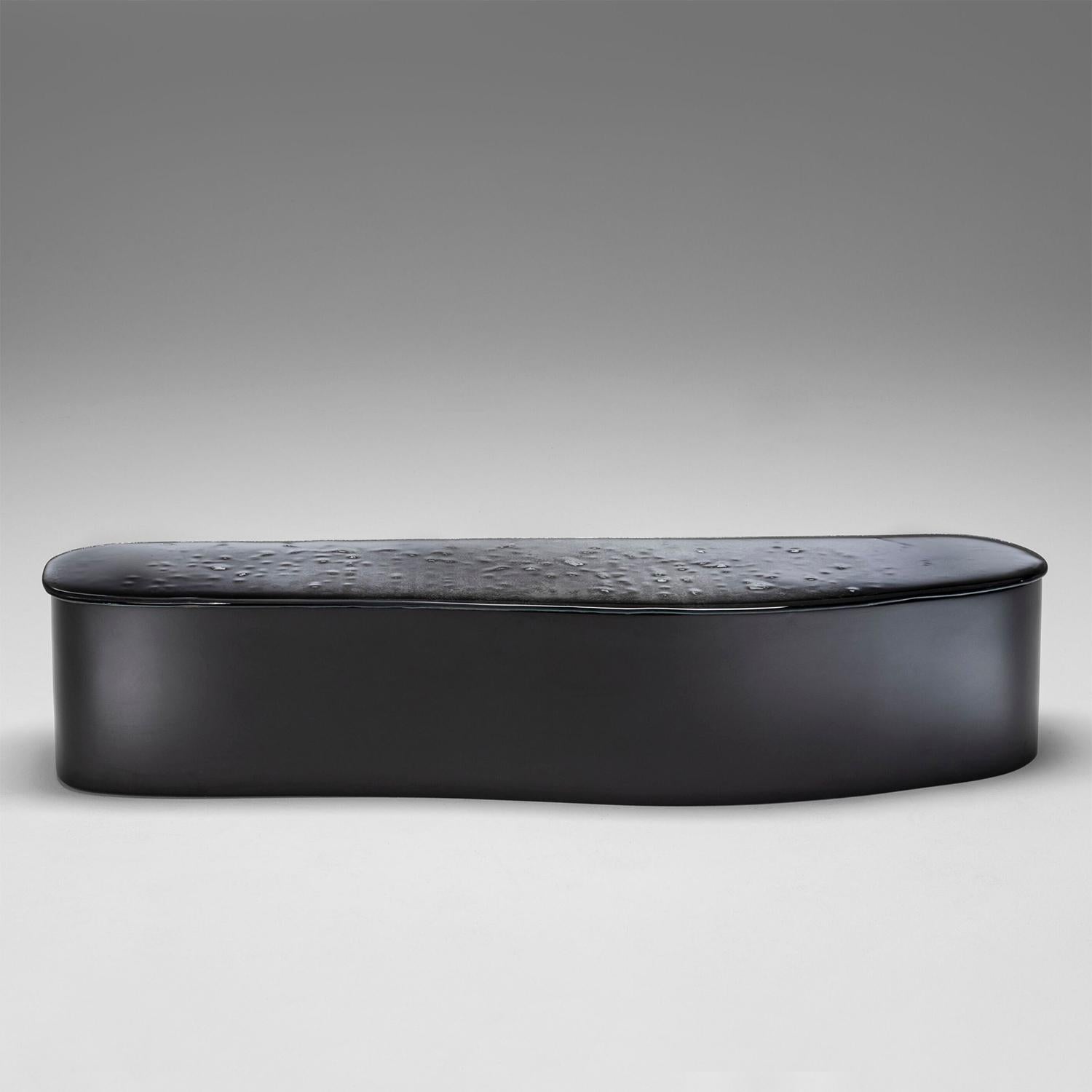 Banc Glass Puddle avec structure en polystyrène intégral
recouvert et peint avec du polyuréthane en fumée mate
finition grise. Dessus constitué de deux couches de verre cuit
avec des bords irréguliers dans un dégradé allant du bleu nuit à l'orange.