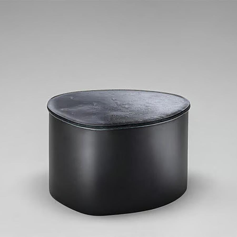 Sgabello Glass Puddle con struttura in polistirene integrale
ricoperta e verniciata con poliuretano in colore fumo opaco
finitura grigia. Top realizzato con due strati di vetro cotto
con bordi irregolari in gradiente da blu notte a 
trasparente e