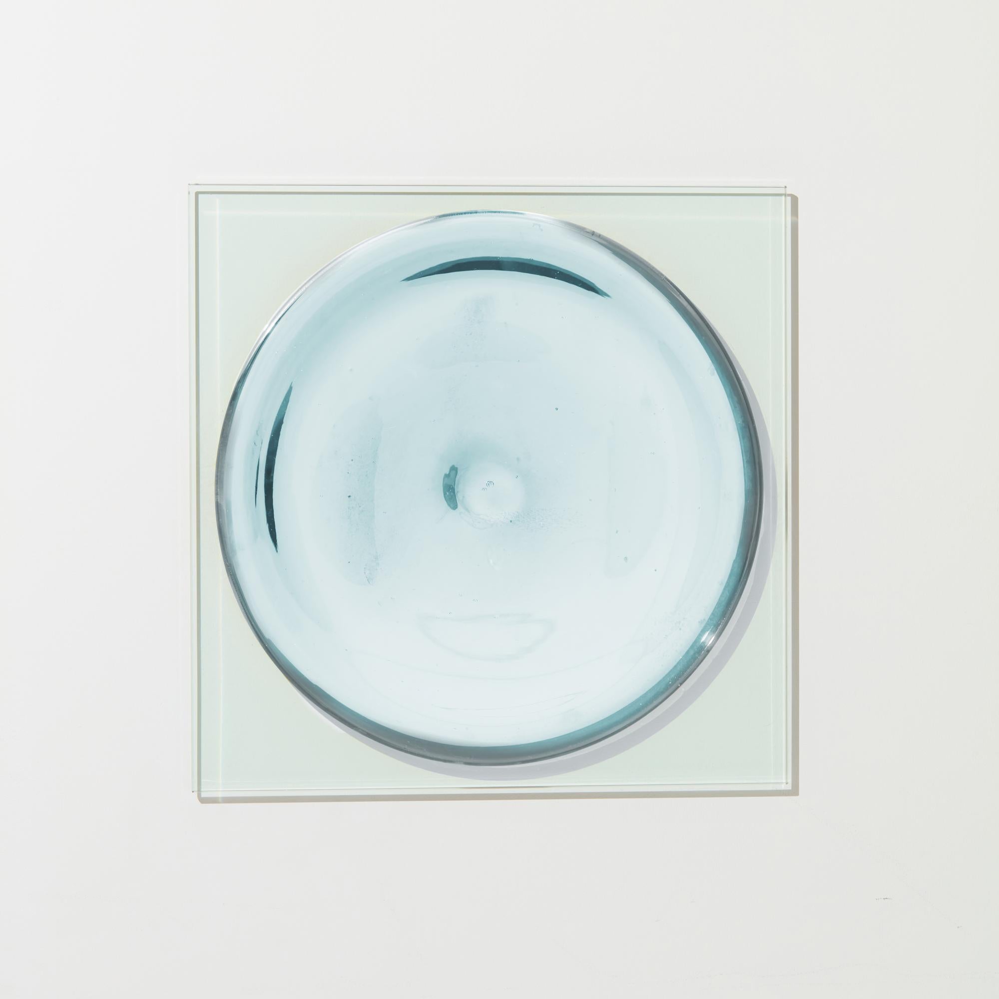Puddle Stone Mirror by Tête Studio
Dimensions: D 91.4 x H 6.6 cm
Materials: Glass.

PUDDLE MIRROR

Built in two parts—a handblown and mirrorized glass rondel centered on a flat square sheet of high-iron glass. The two forms juxtapose rigid geometry