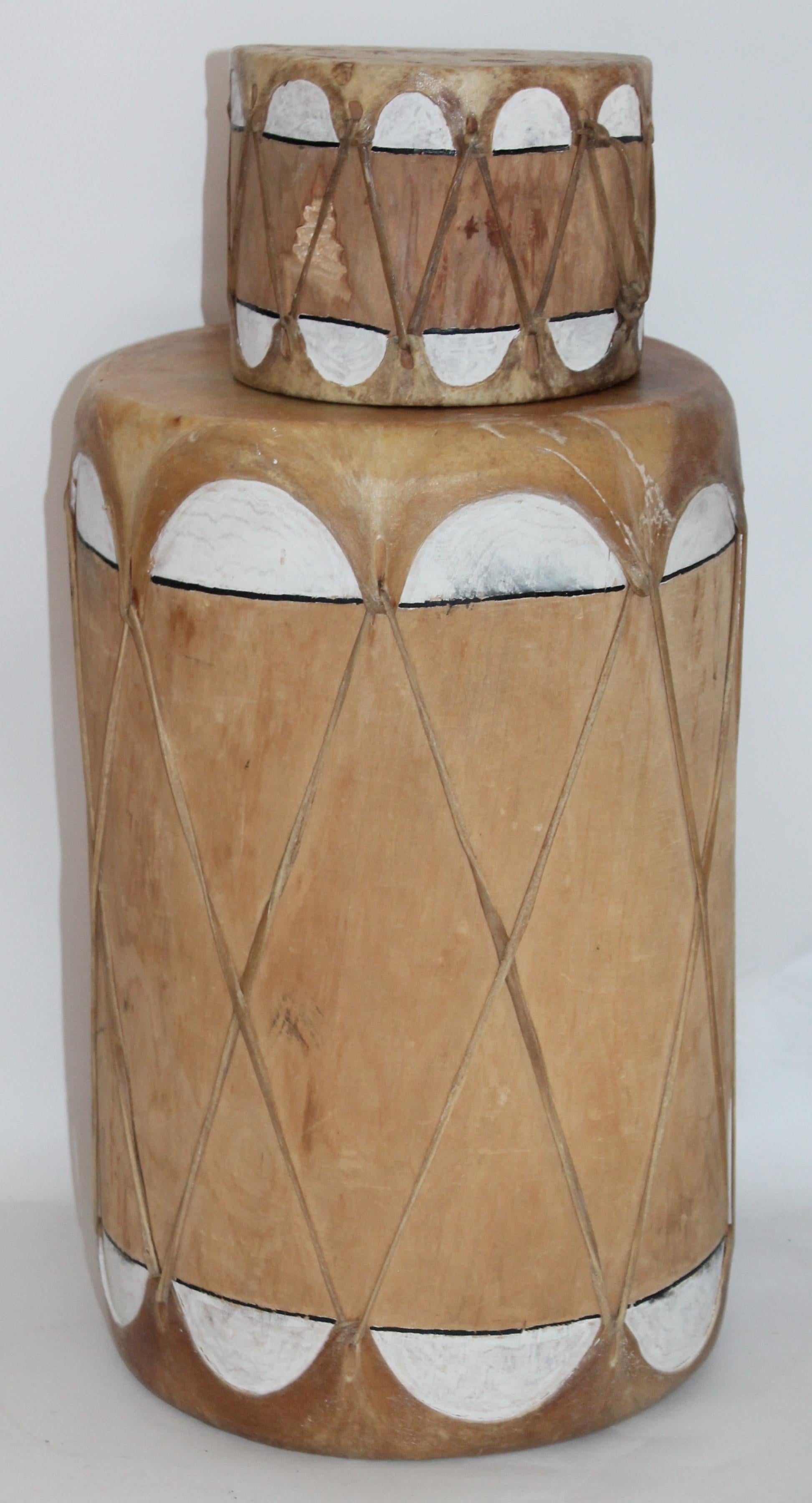 Pueblo drum set of matching drums.

Set of 2 natural colored drums with white accents.
The drums are made of leather and wood. 

Smaller drum measures - 6 x 4 
Larger drum measures - 10 x 16.